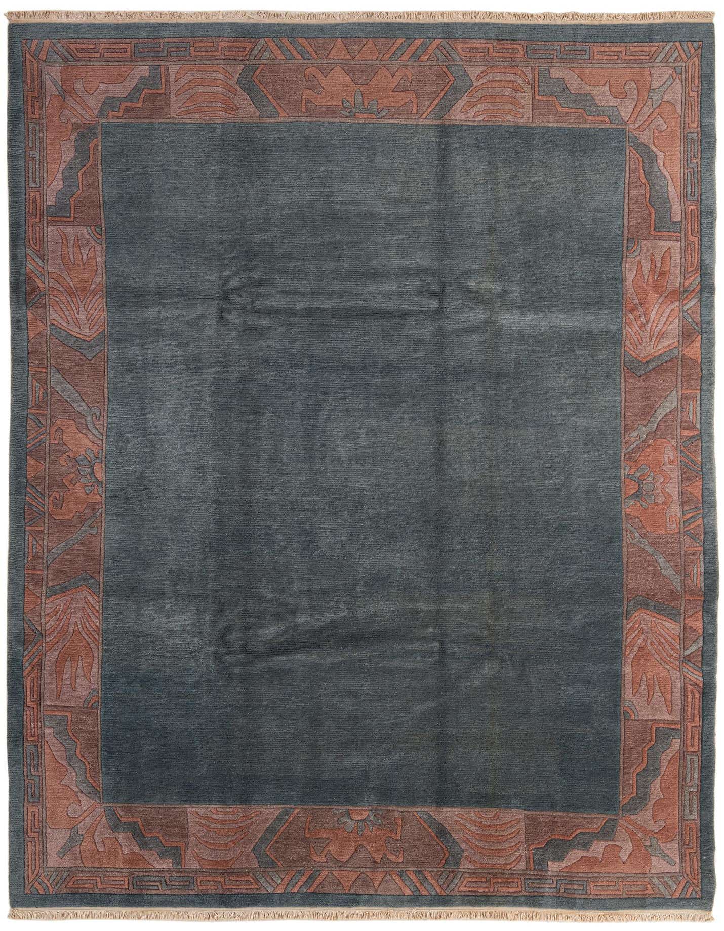 A rectangular 8x11 blue wool rug with a medium pile, featuring a wide border in earthy red and brown tones with abstract and oriental patterns.