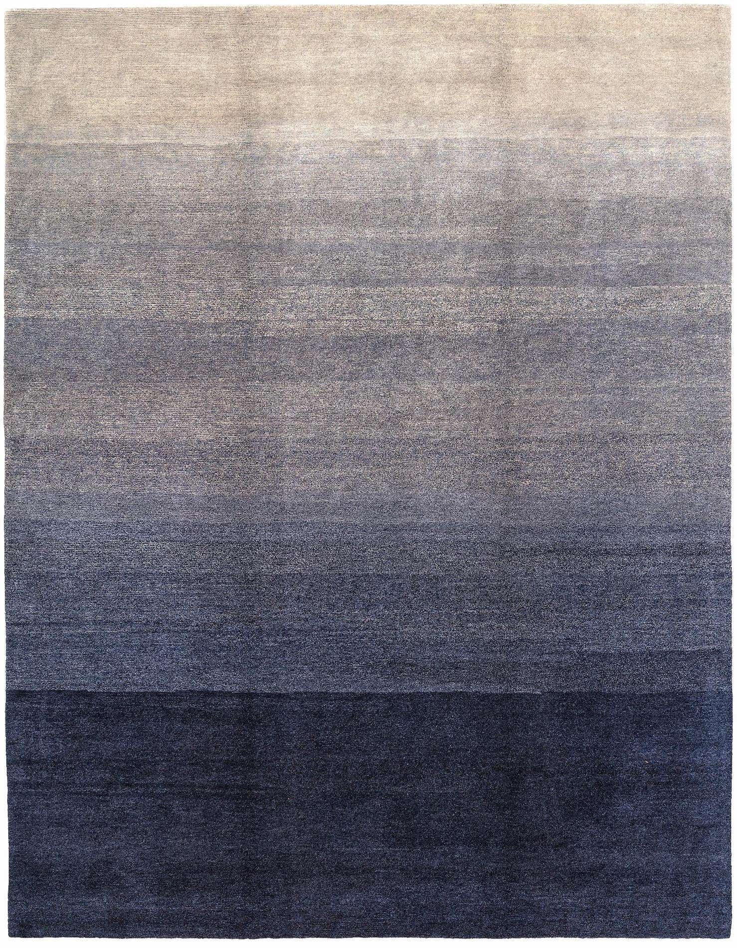 A 6x9 rectangular area rug with a blue ombre design, transitioning from light blue-grey to deep navy.