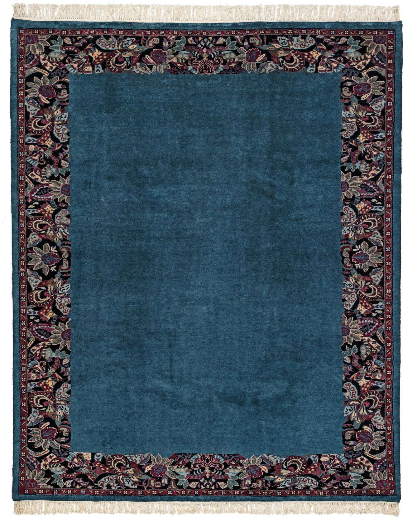 A 7x10 rectangular blue wool rug with a dark, ornate floral border, suitable for a living room.