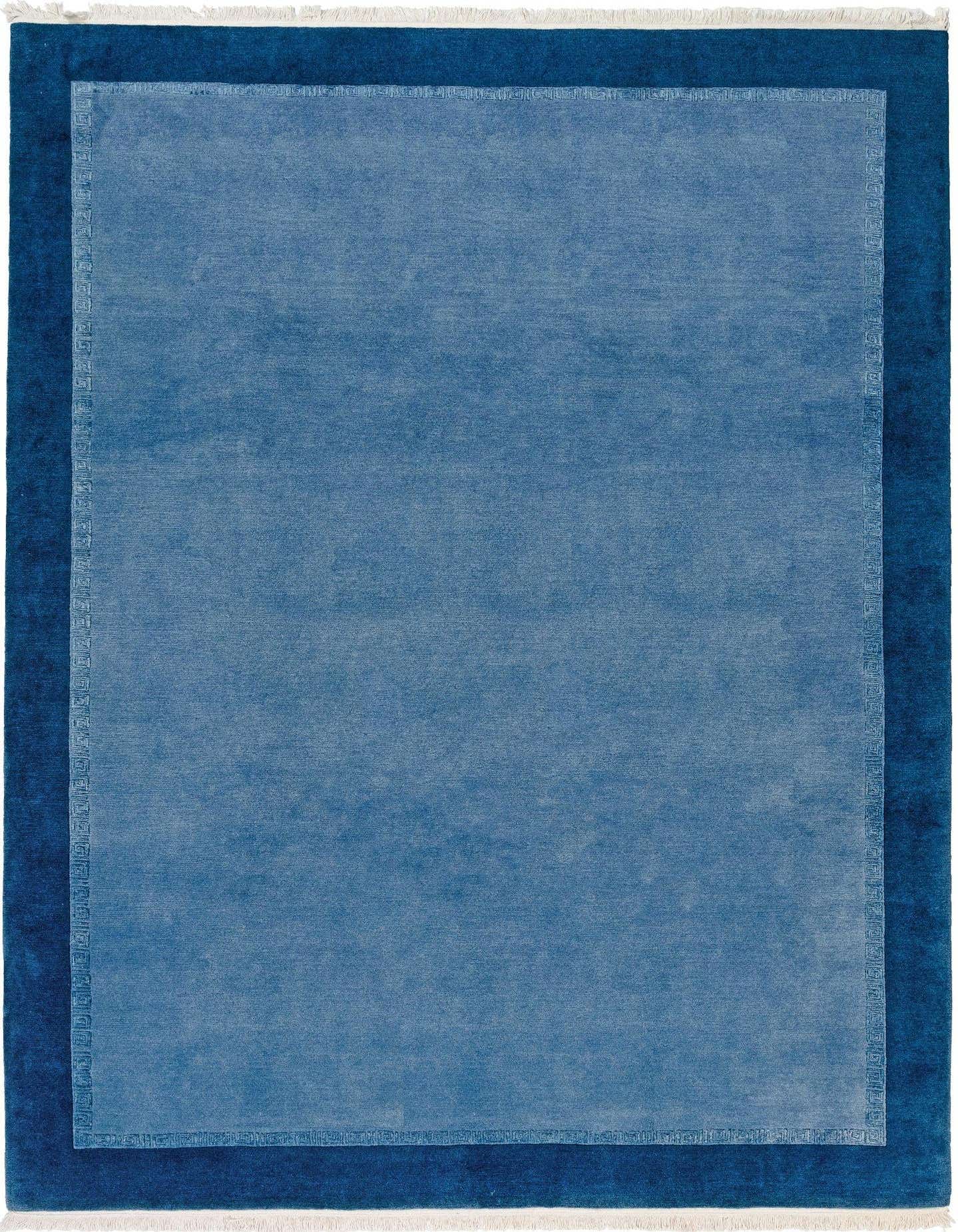 A 6x9 rectangular blue modern rug with a solid light blue center and a darker blue border featuring a subtle geometric pattern.