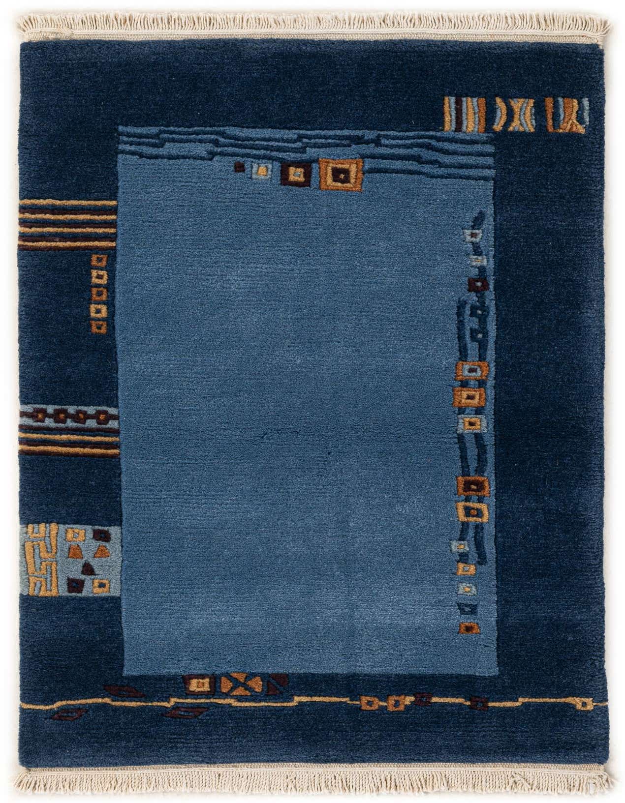 A 2x3 rectangular modern wool rug featuring a deep blue border and a lighter blue center, with abstract geometric patterns in brown and gold.