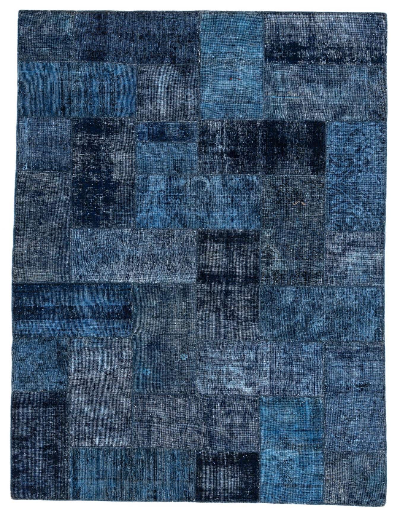 A 7x10 rectangular Ultra Vintage rug by Rugs.com, featuring a patchwork of varying blue and navy distressed patterns, suitable for a living room.