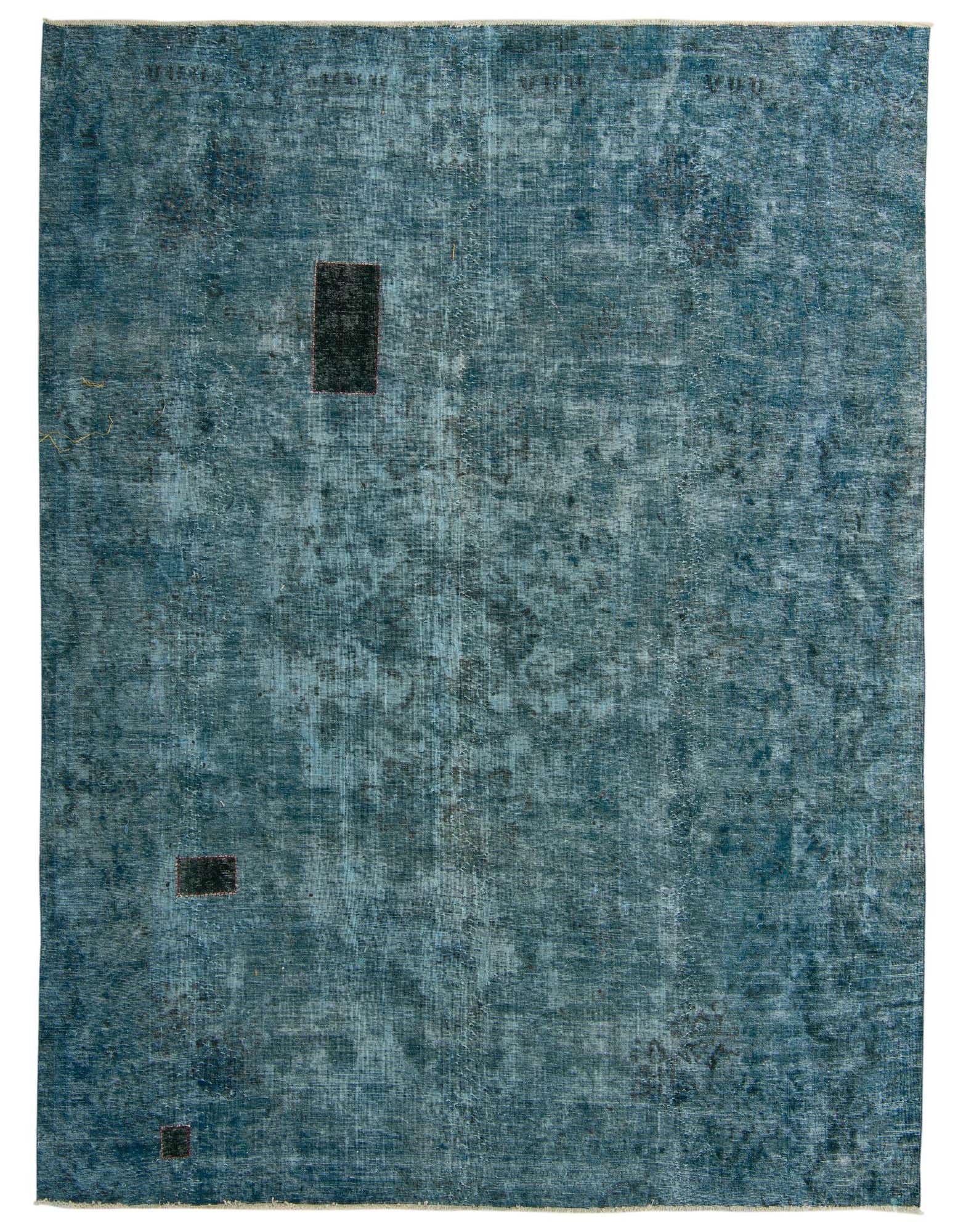A 9x12 rectangular Ultra Vintage rug in varying shades of blue with a distressed Persian-inspired pattern and three small dark rectangular patches.