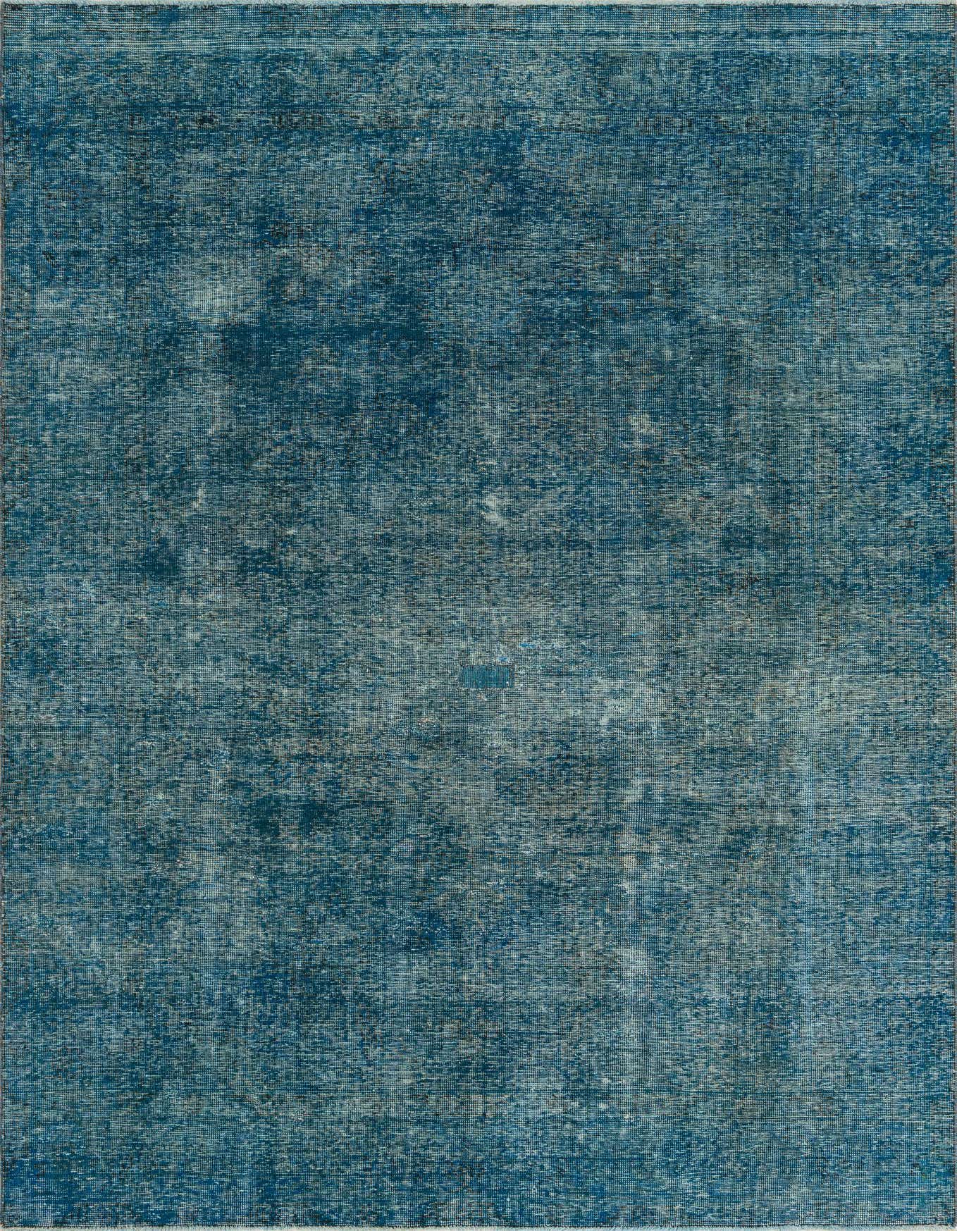 A 7x10 rectangular blue wool area rug with a subtle, distressed Persian medallion pattern, perfect for a living room.