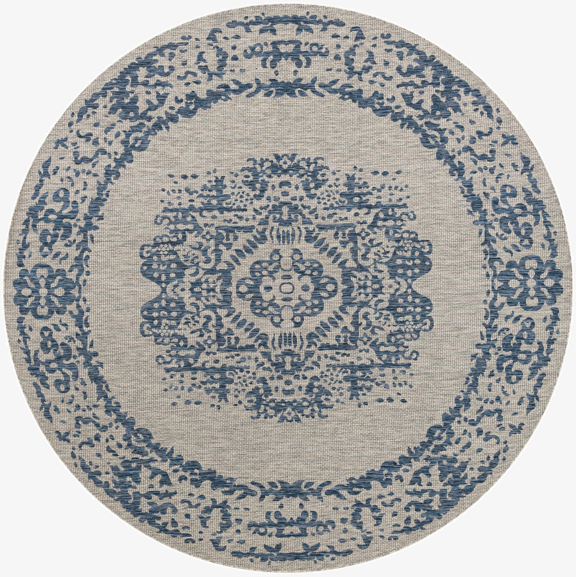 A 10-foot round indoor/outdoor rug with a blue medallion and border pattern on a beige flatweave background.