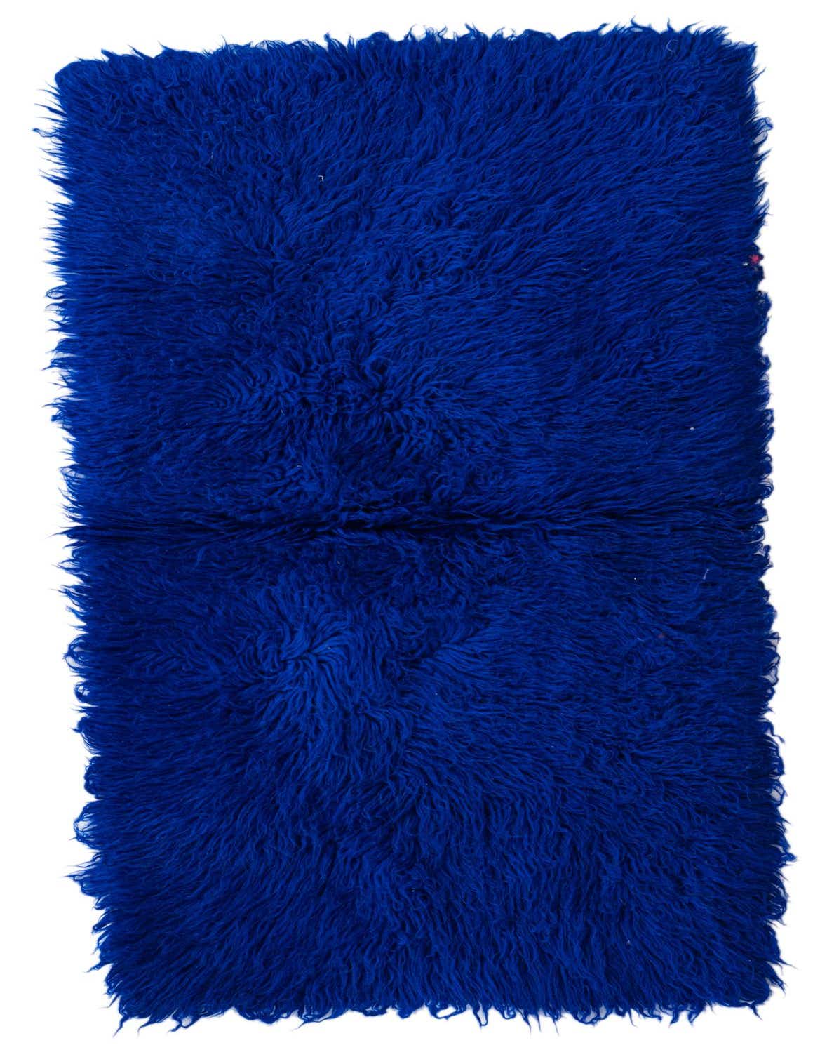 A plush, royal blue shag runner rug made of wool, perfect for adding a vibrant accent to a hallway.