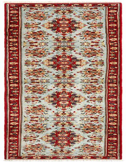 A 13 ft runner rug with a light blue field and intricate red, gold, and blue Persian floral patterns, bordered by a rich red band.