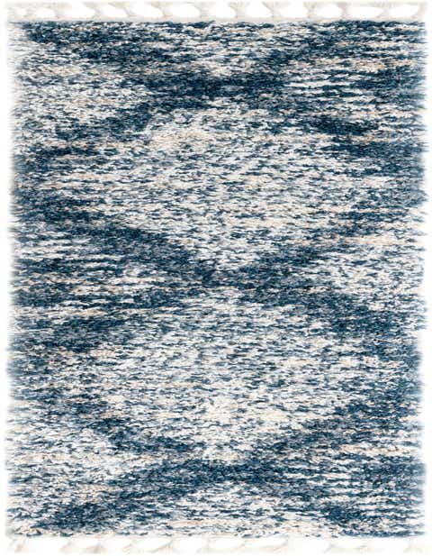 A soft 8 ft Serenity Shag runner rug in varying shades of blue, white, and beige, with a textured pile and decorative tassels.