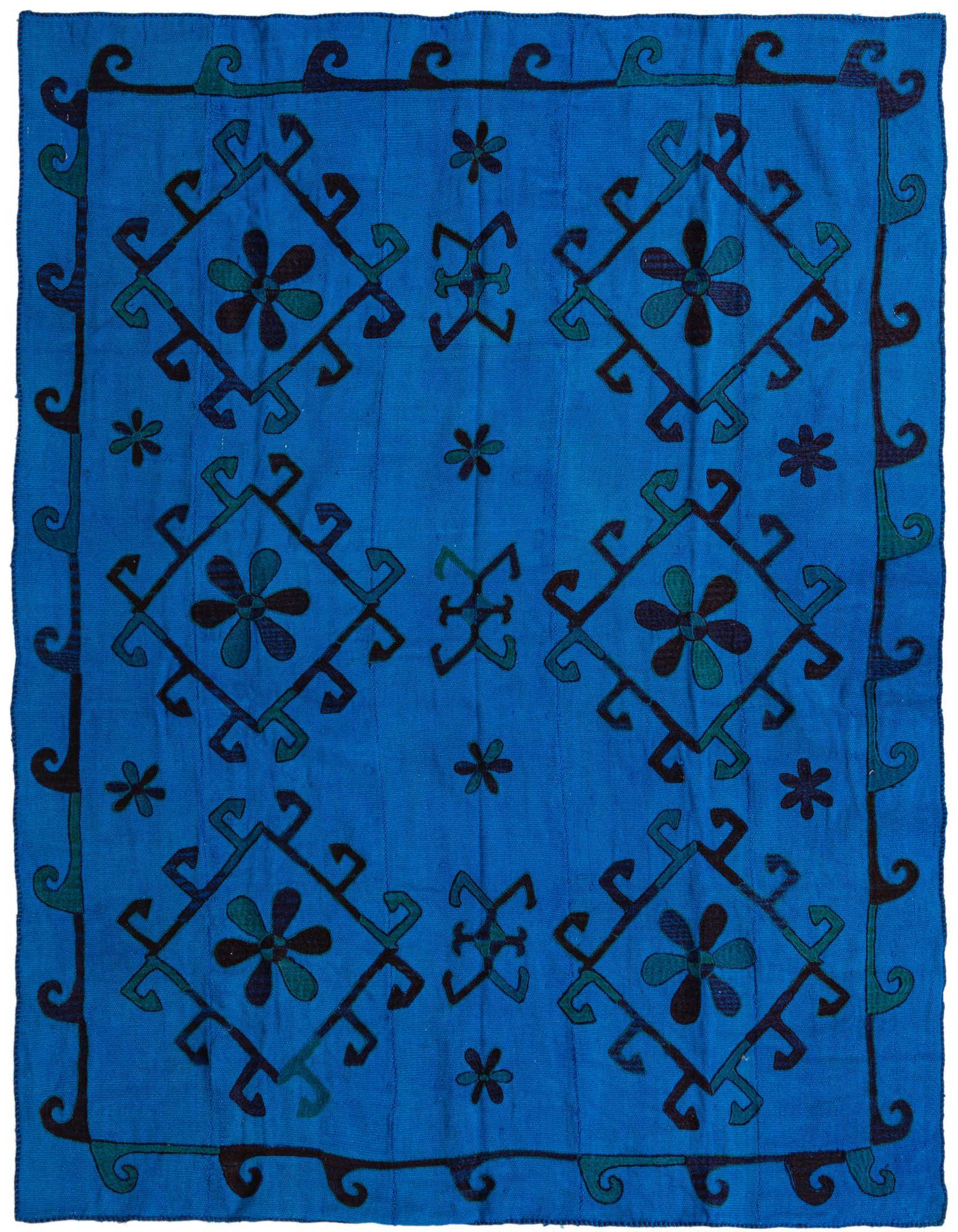 A vibrant blue square Kilim Suzani rug with a tribal pattern of dark blue and teal floral motifs and geometric shapes.