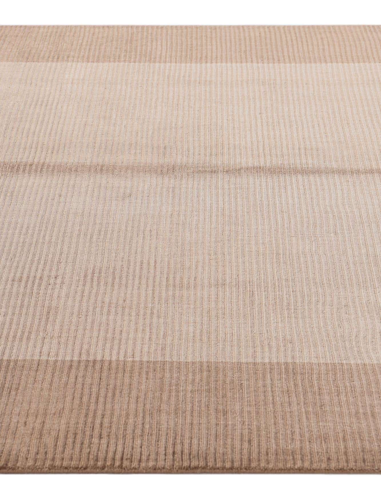 A close-up of a 5x8 rectangular Darya rug with alternating light and dark brown striped patterns, showcasing its high pile texture.