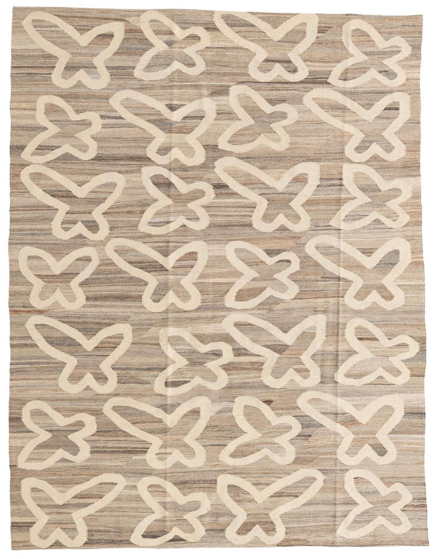 A 6x9 rectangular Rugs.com Kilim Modern wool rug with a tribal butterfly pattern in varying shades of brown and tan.