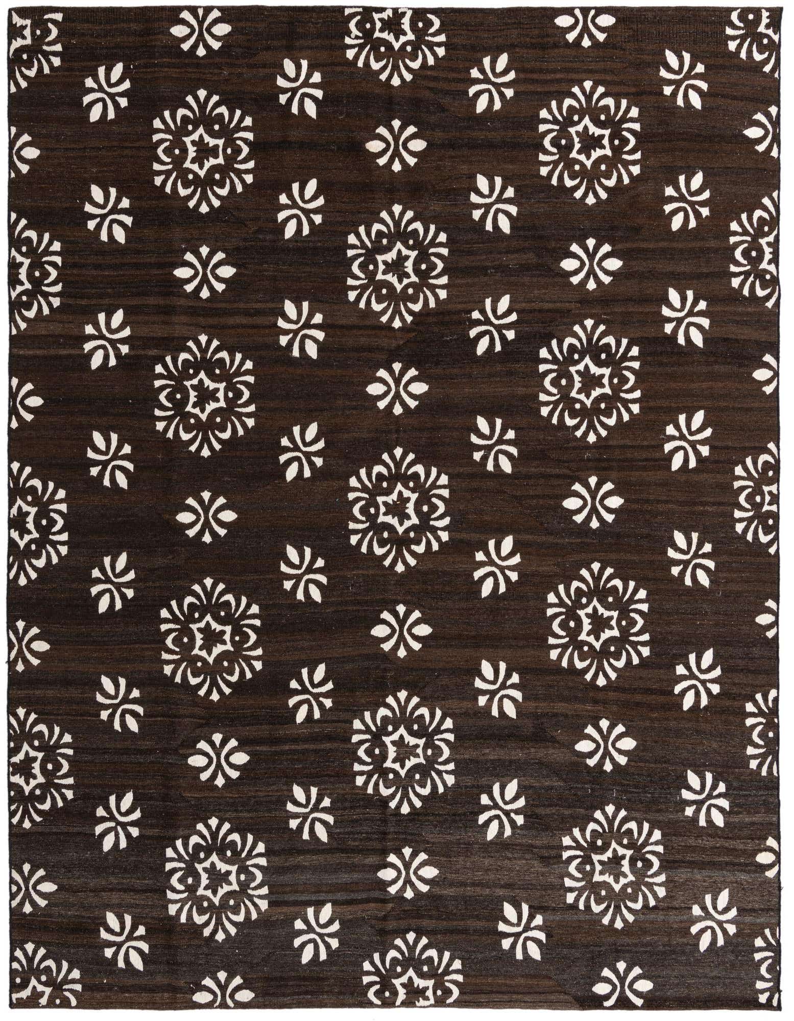 An 8x10 rectangular brown flatweave rug with a scattered pattern of white tribal floral motifs.
