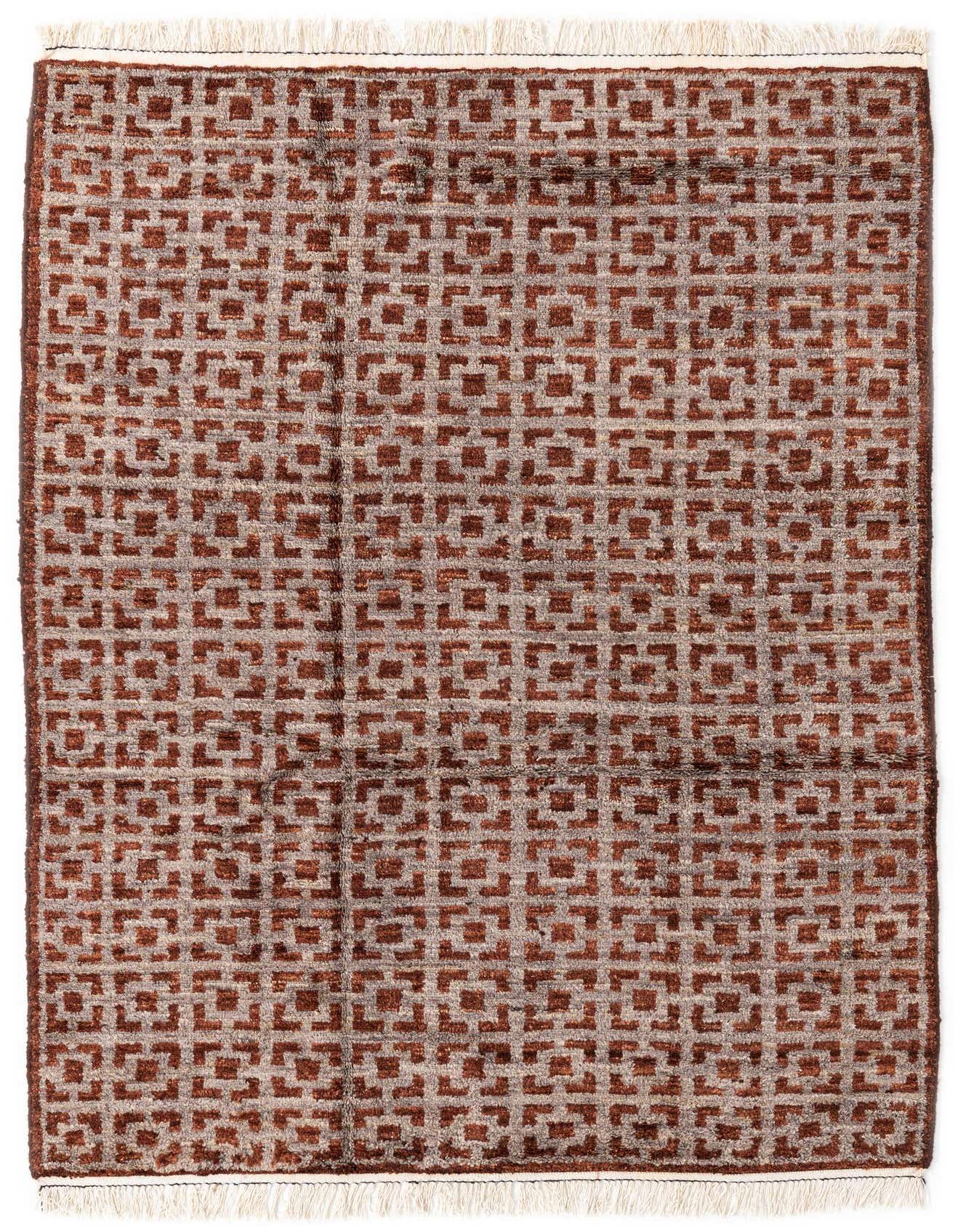 A rectangular 5x8 brown and tan wool shag rug with a repeating geometric pattern and fringed ends.