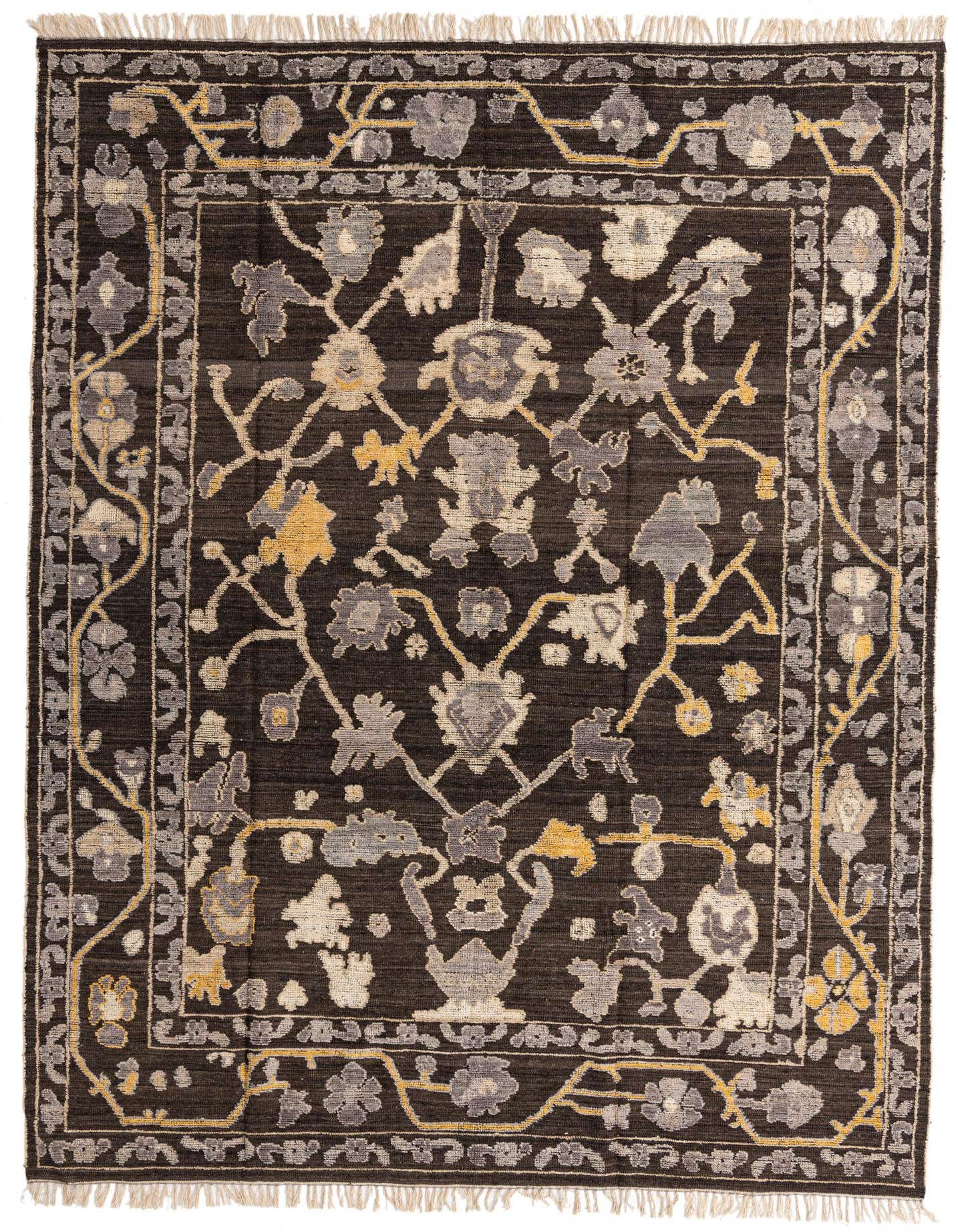A 9x12 rectangular Oushak wool rug in dark brown with an abstract floral pattern in shades of tan, grey, and yellow, featuring a decorative border and fringed ends.