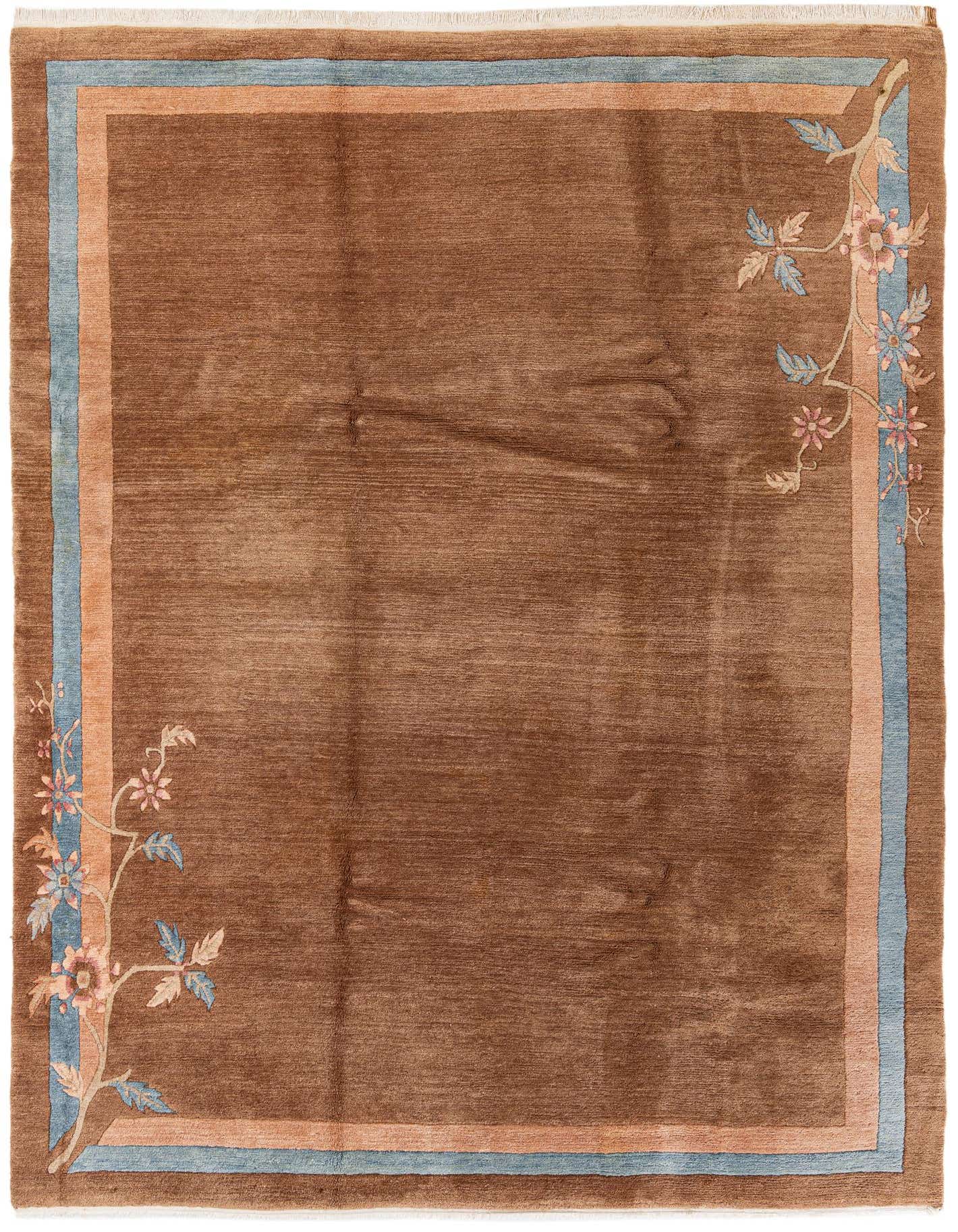 A rectangular 8x11 brown wool area rug with a light blue and tan border, featuring delicate floral patterns in the corners.
