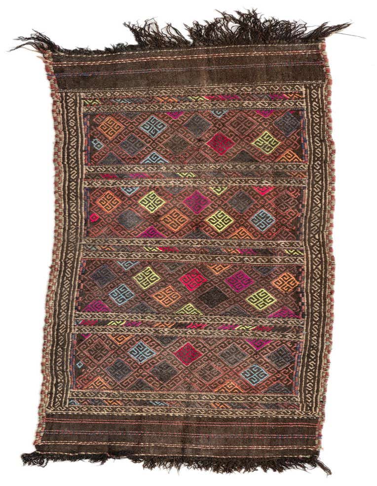 A 6 ft runner rug with a brown background and colorful tribal geometric patterns, featuring diamond and abstract shapes, and fringed ends.