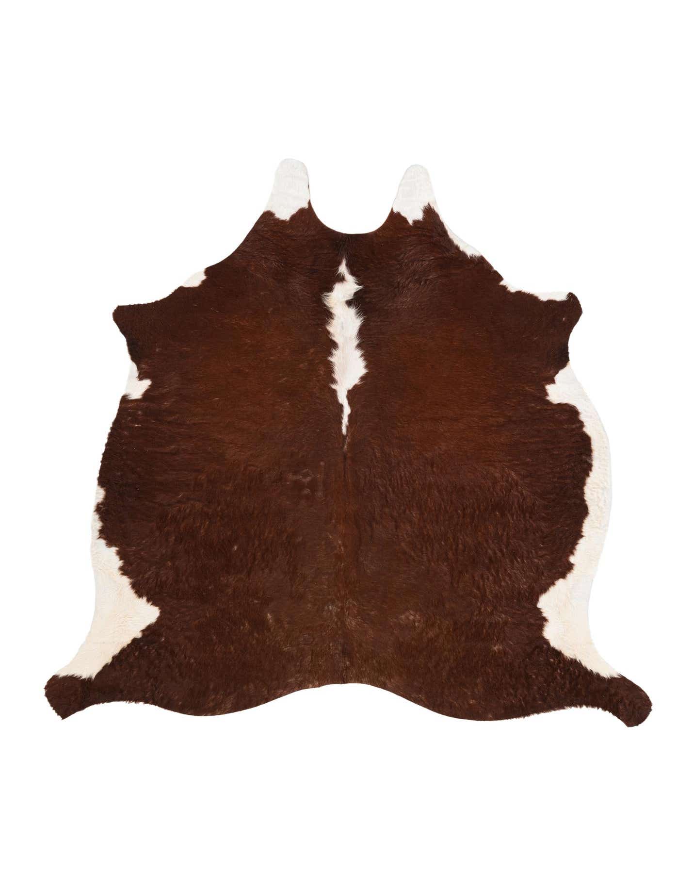 A brown and white cowhide rug with an irregular, organic shape, featuring a prominent white stripe down the center.