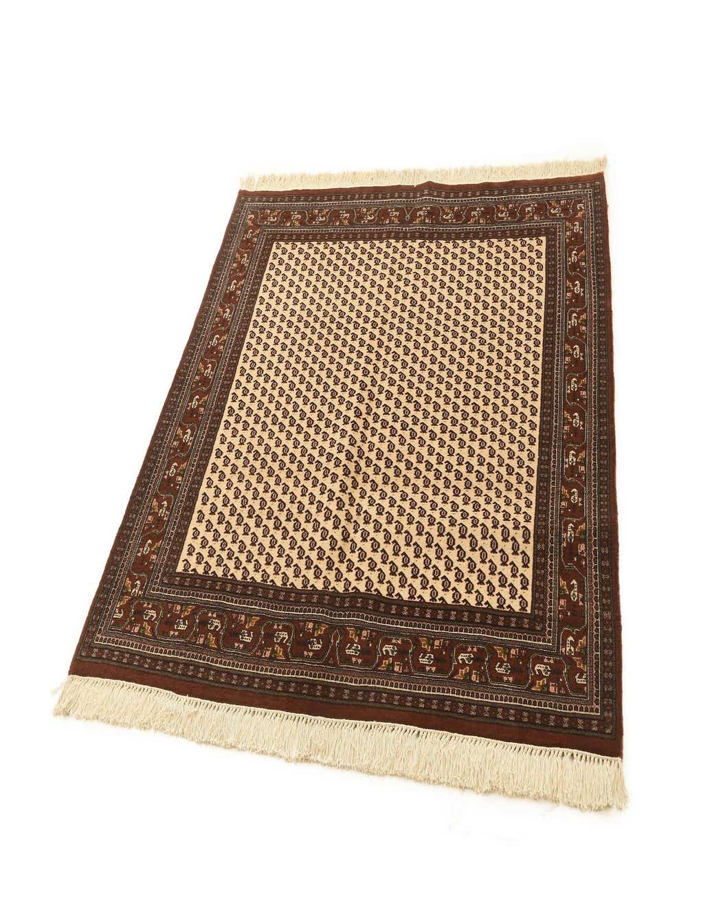 A 5' 1 x 5' 1 square wool rug with a tan field and repeating brown paisley-like patterns, framed by a wide dark brown border with intricate traditional motifs and fringe.