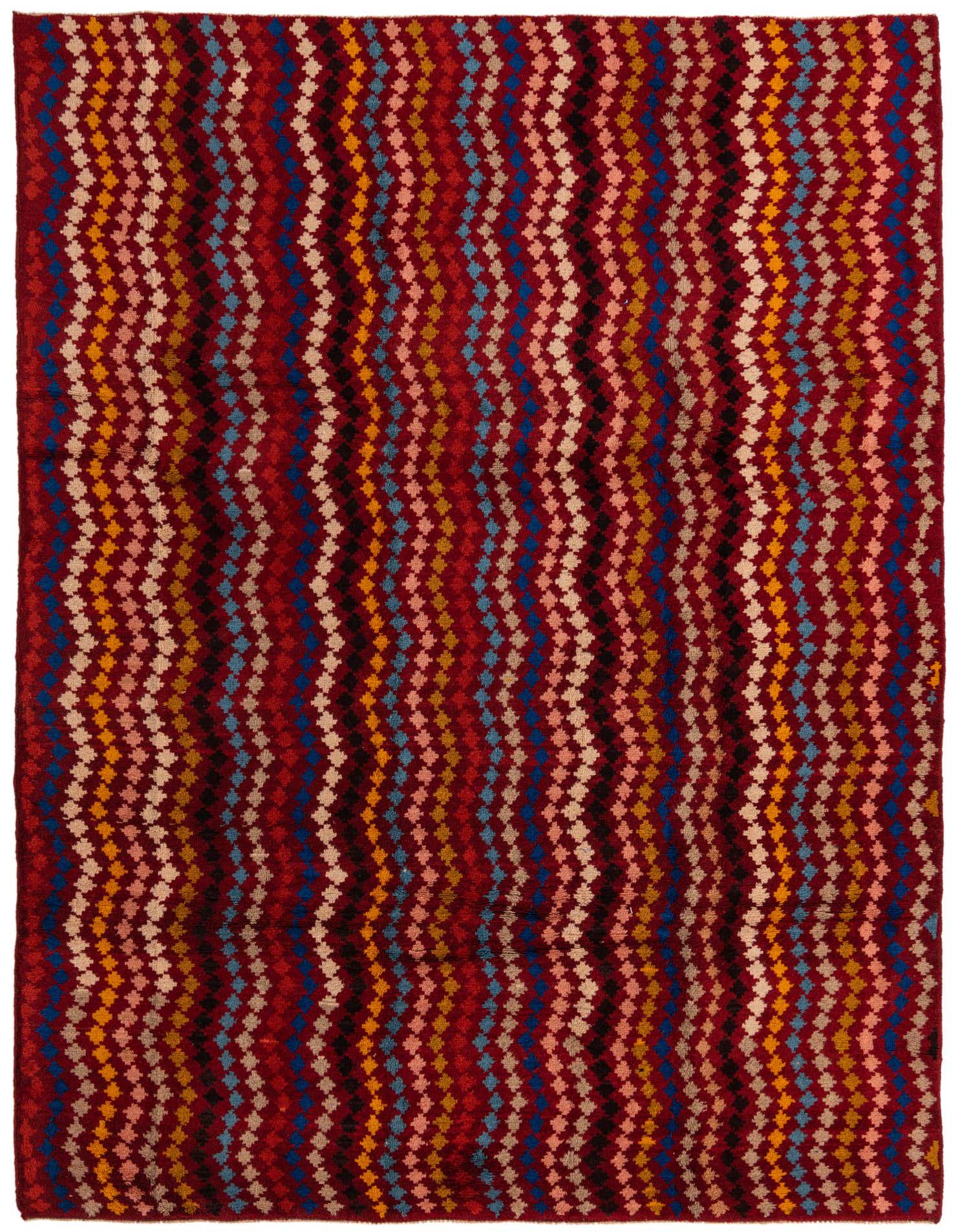A 6x9 rectangular Balouch rug with a tribal, abstract pattern in shades of red, blue, yellow, and beige.