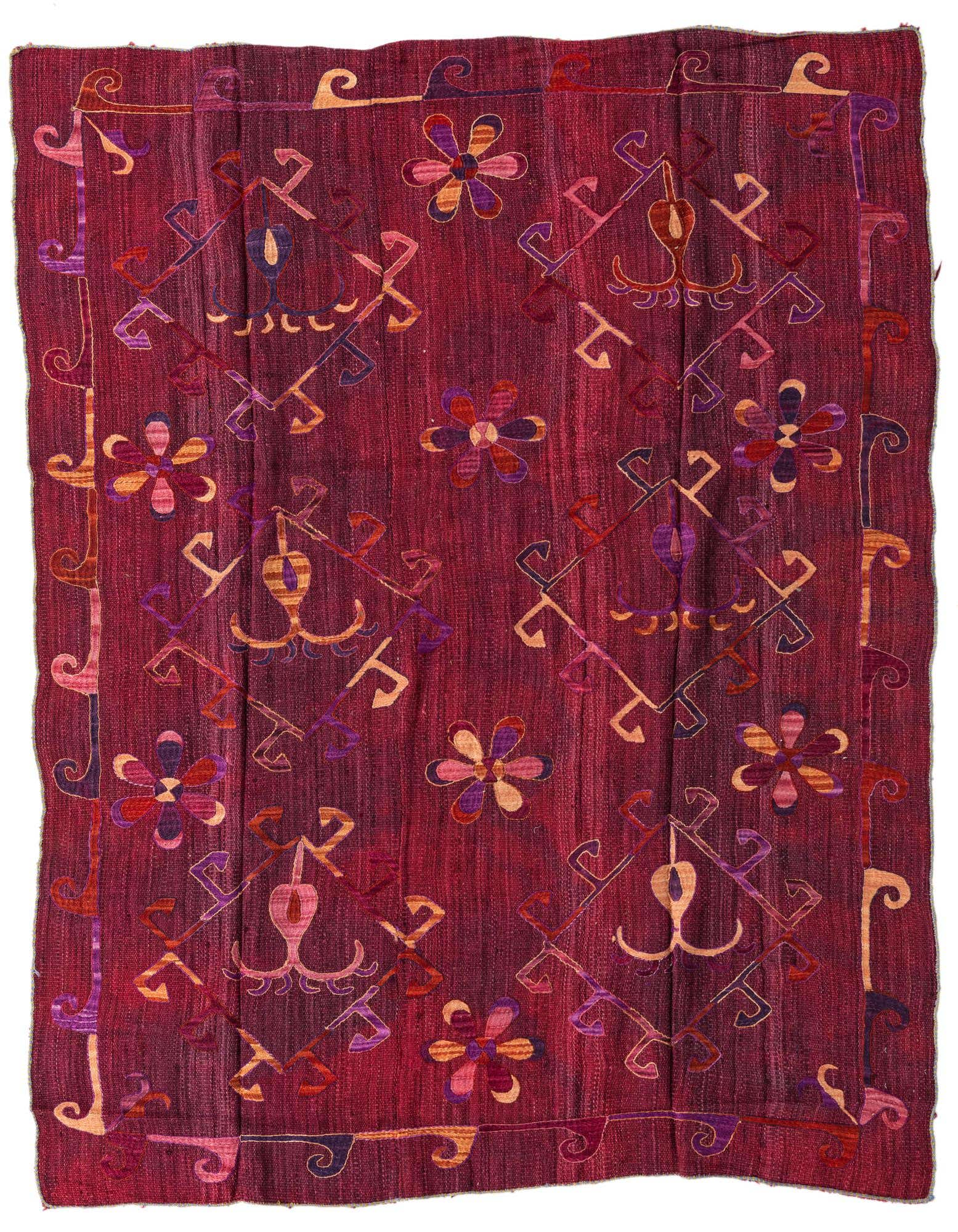 A 5x8 rectangular red Kilim Suzani wool rug featuring colorful tribal and floral patterns in purples, oranges, and pinks.