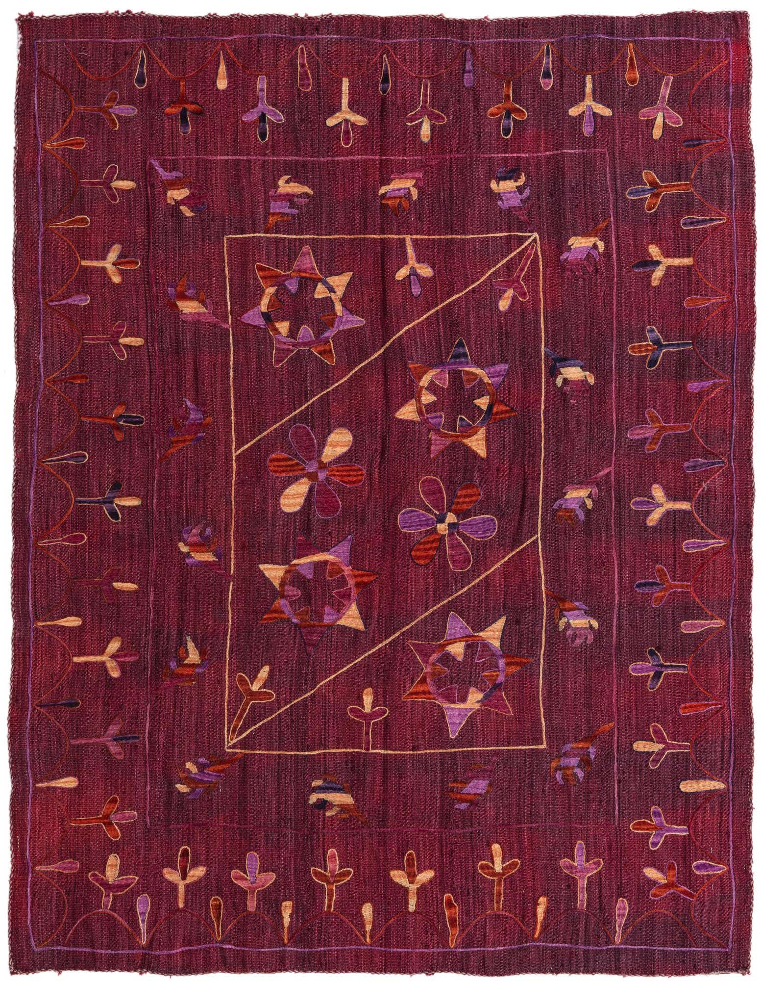 A 5x8 rectangular Kilim Suzani rug in deep reds, featuring a central abstract pattern of stars and flowers, with tribal motifs along the border.