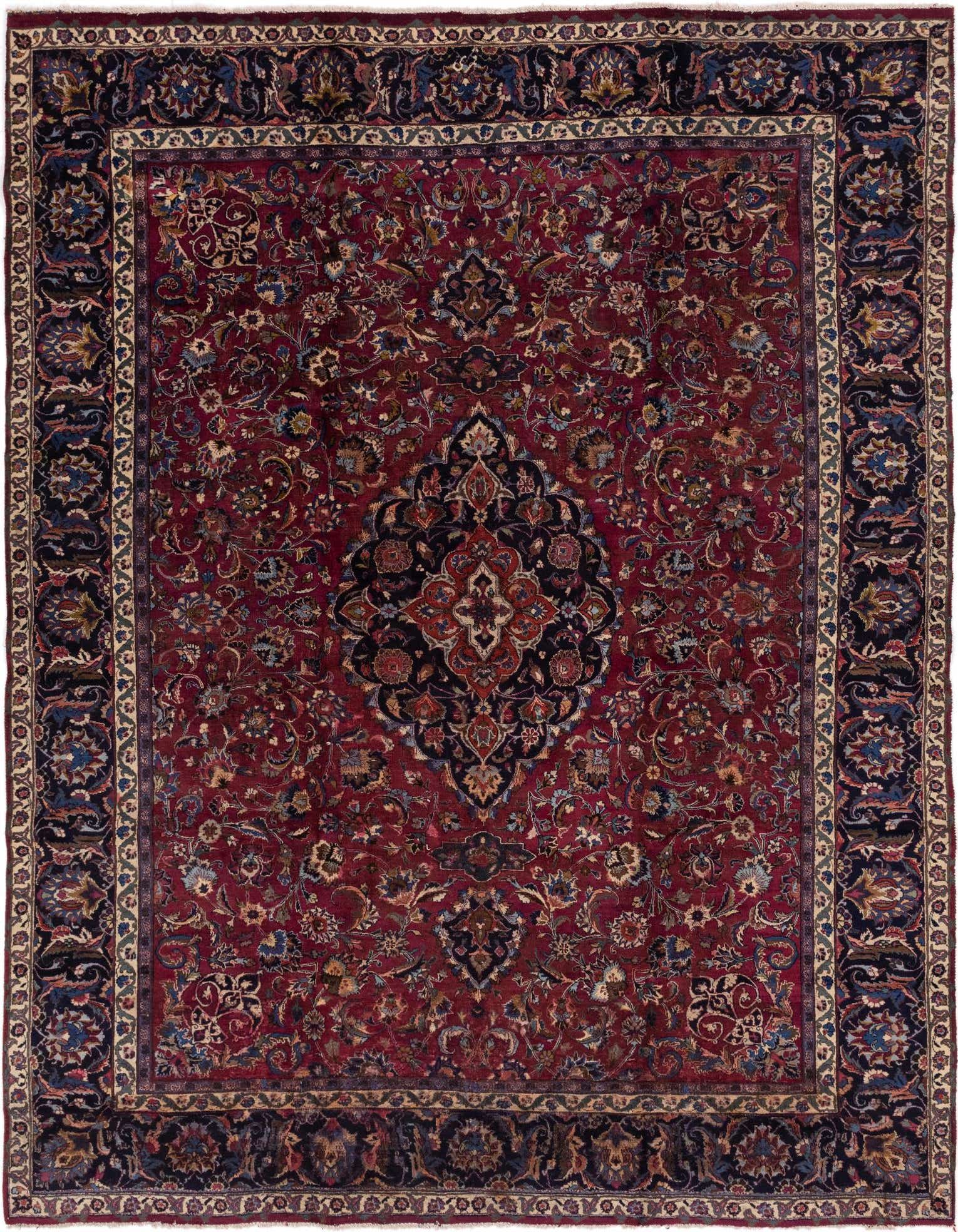 A 10x13 rectangular Mashad Persian rug with a deep red field and intricate botanical medallion pattern, framed by a dark blue border.