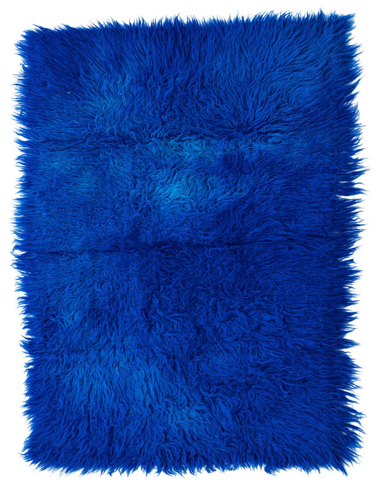 A vibrant 3x4 rectangular shag rug in deep blue with subtle variations, adding texture and color to an indoor space.