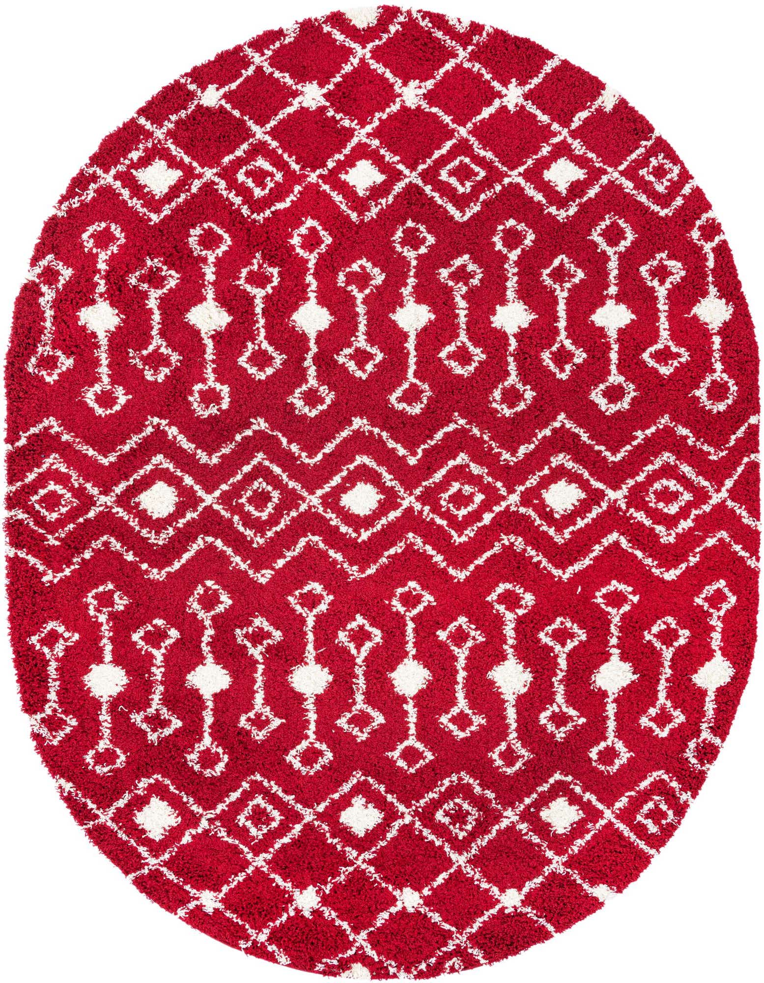 A vibrant red oval shag rug with a white tribal geometric pattern, featuring diamonds and linked shapes.