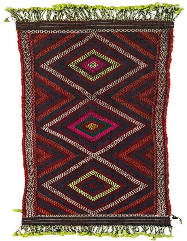 A 9 ft runner rug from the Kilim Fars collection, featuring a vibrant red tribal geometric pattern with colorful diamond accents and lime green fringes.