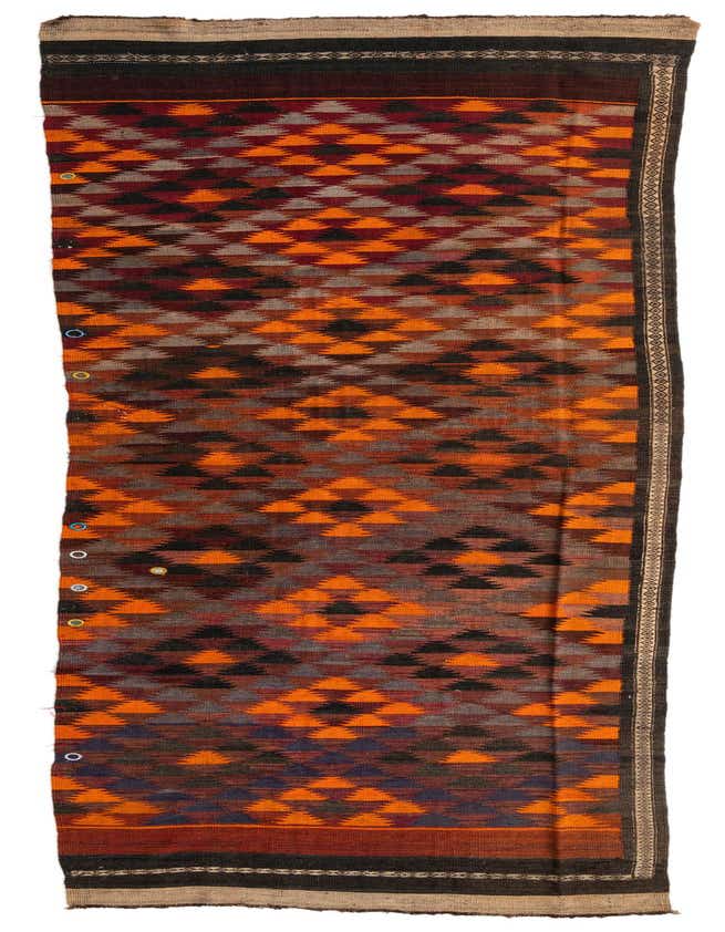 A 15 ft runner rug with a tribal pattern in shades of red, orange, brown, and black, featuring geometric diamond shapes.