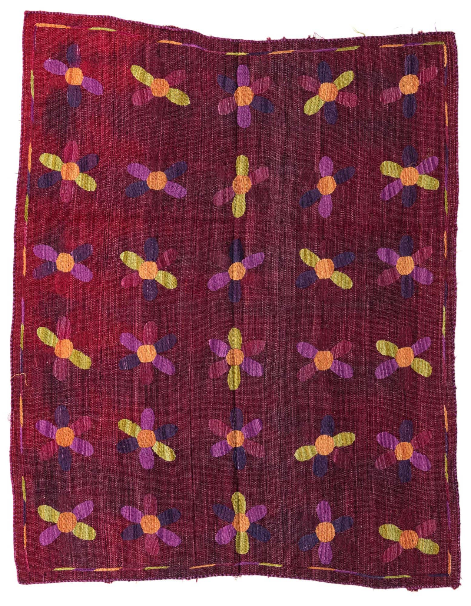 A 5'4" x 6'0" square Kilim Suzani rug featuring a vibrant floral pattern in purple, orange, and lime green on a rich red flatweave wool background.