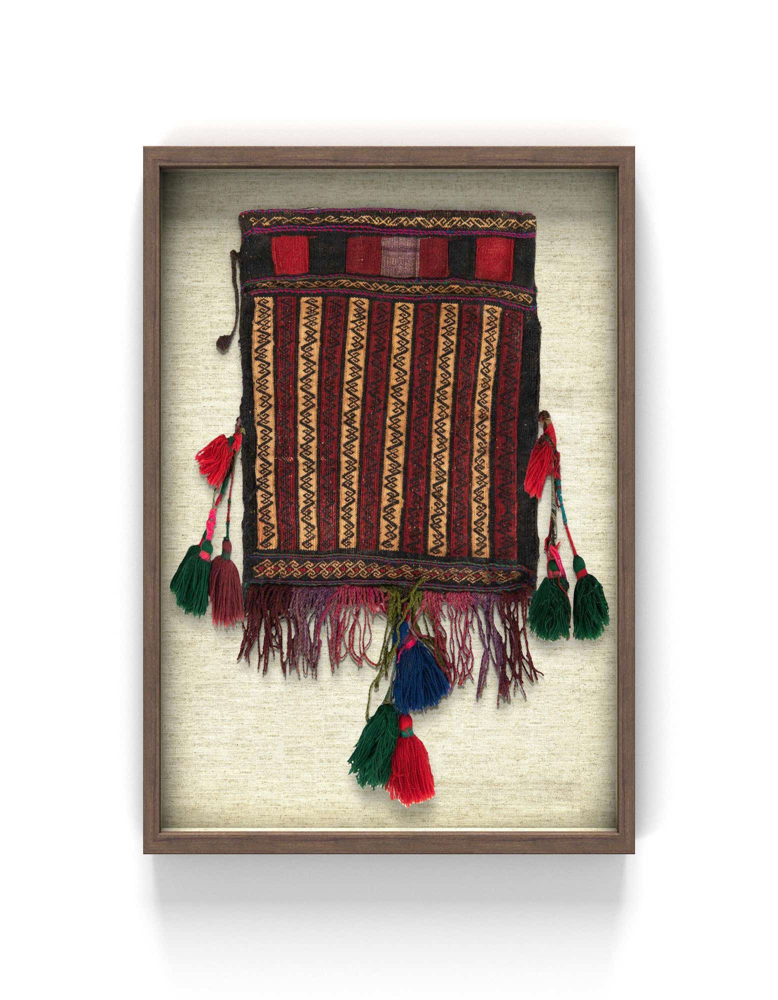 A framed square textile wall art piece featuring red, black, and gold stripes with colorful tassels.