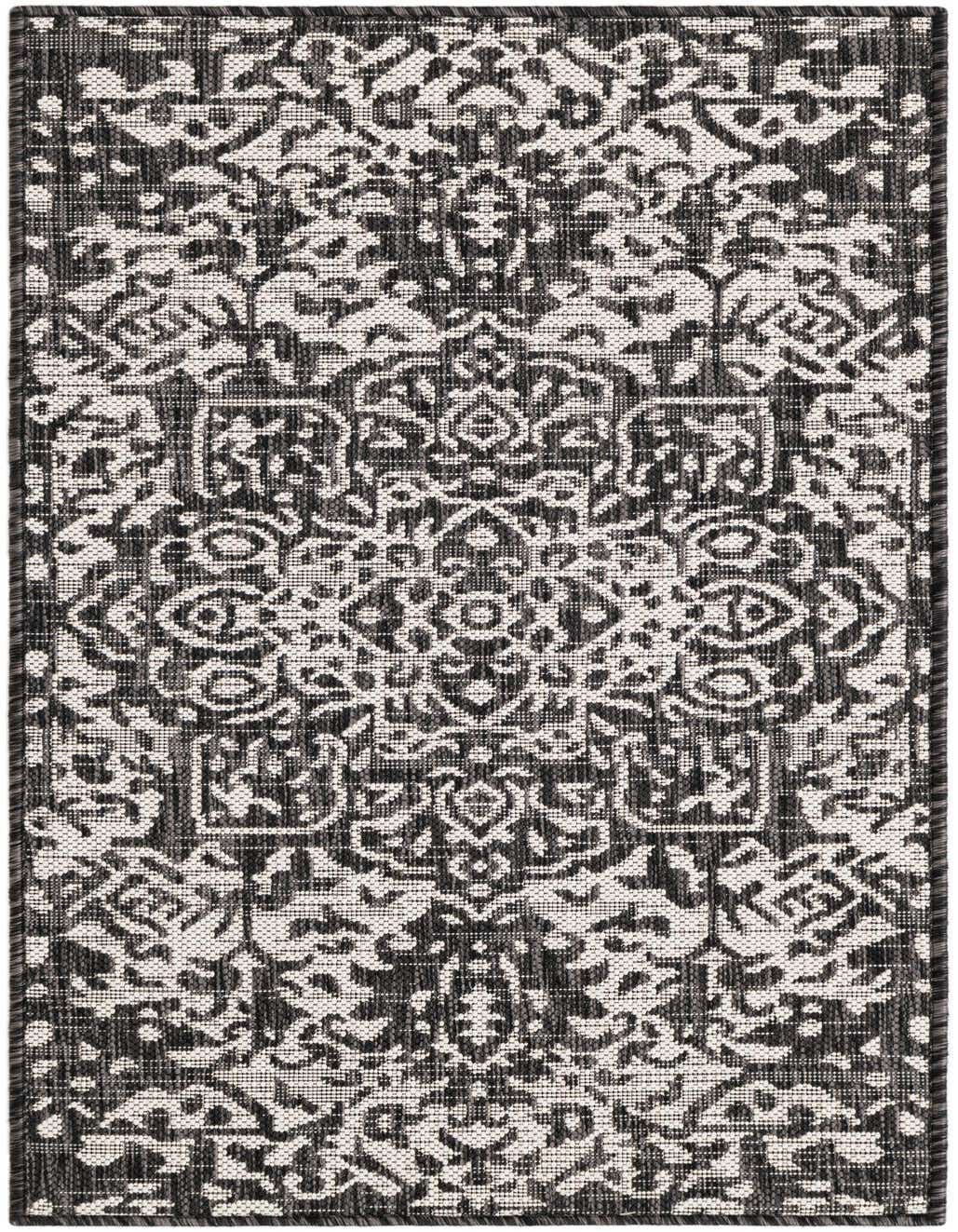 A 4 ft runner rug from the Jill Zarin Outdoor collection, featuring a distressed black and off-white traditional pattern.