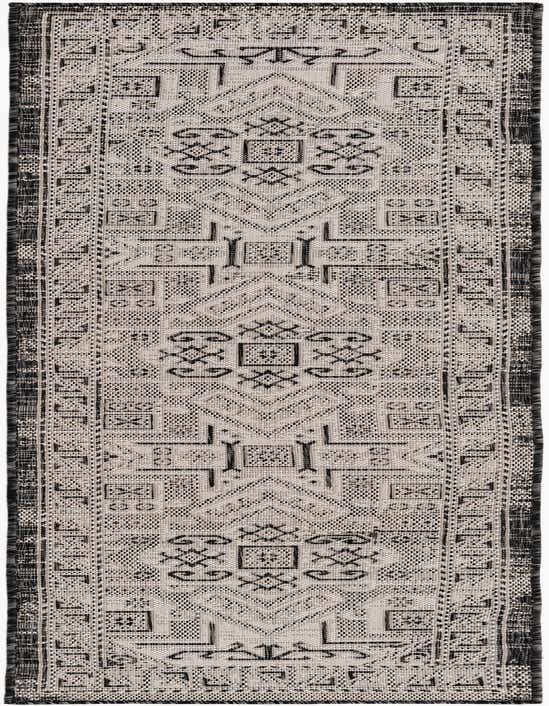 An 8 ft runner rug from the Outdoor Aztec collection, featuring a black and gray Southwestern tribal pattern with a flatweave texture.