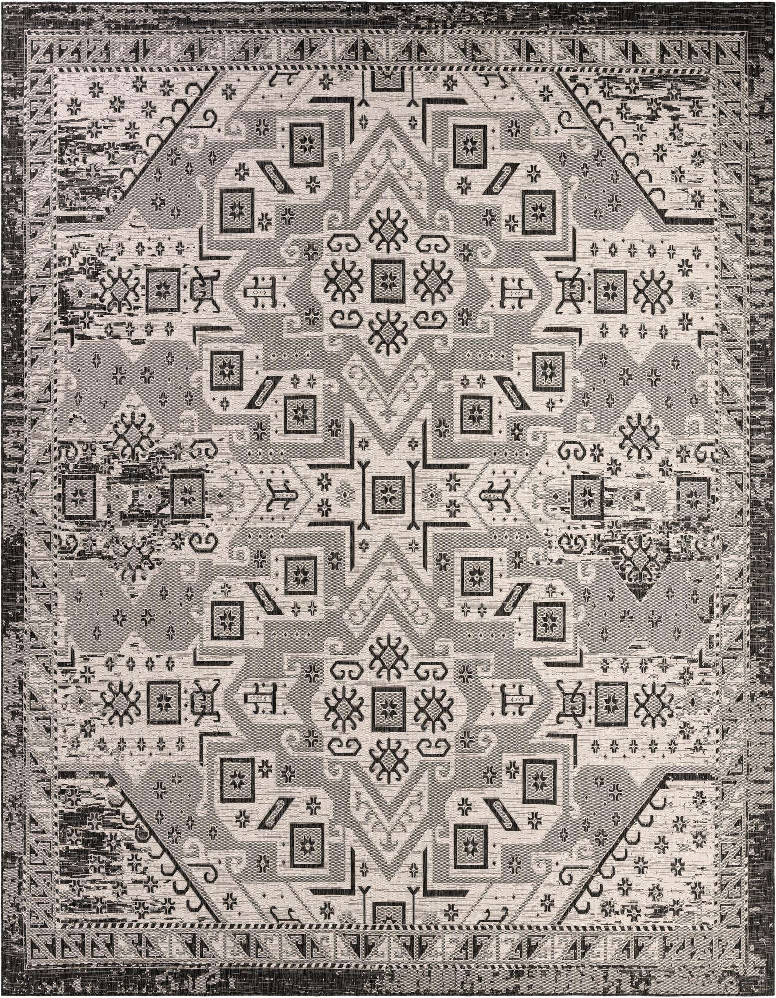 A 13' square Rugs.com Outdoor Aztec rug featuring a distressed tribal geometric pattern in black and gray tones, suitable for a patio.