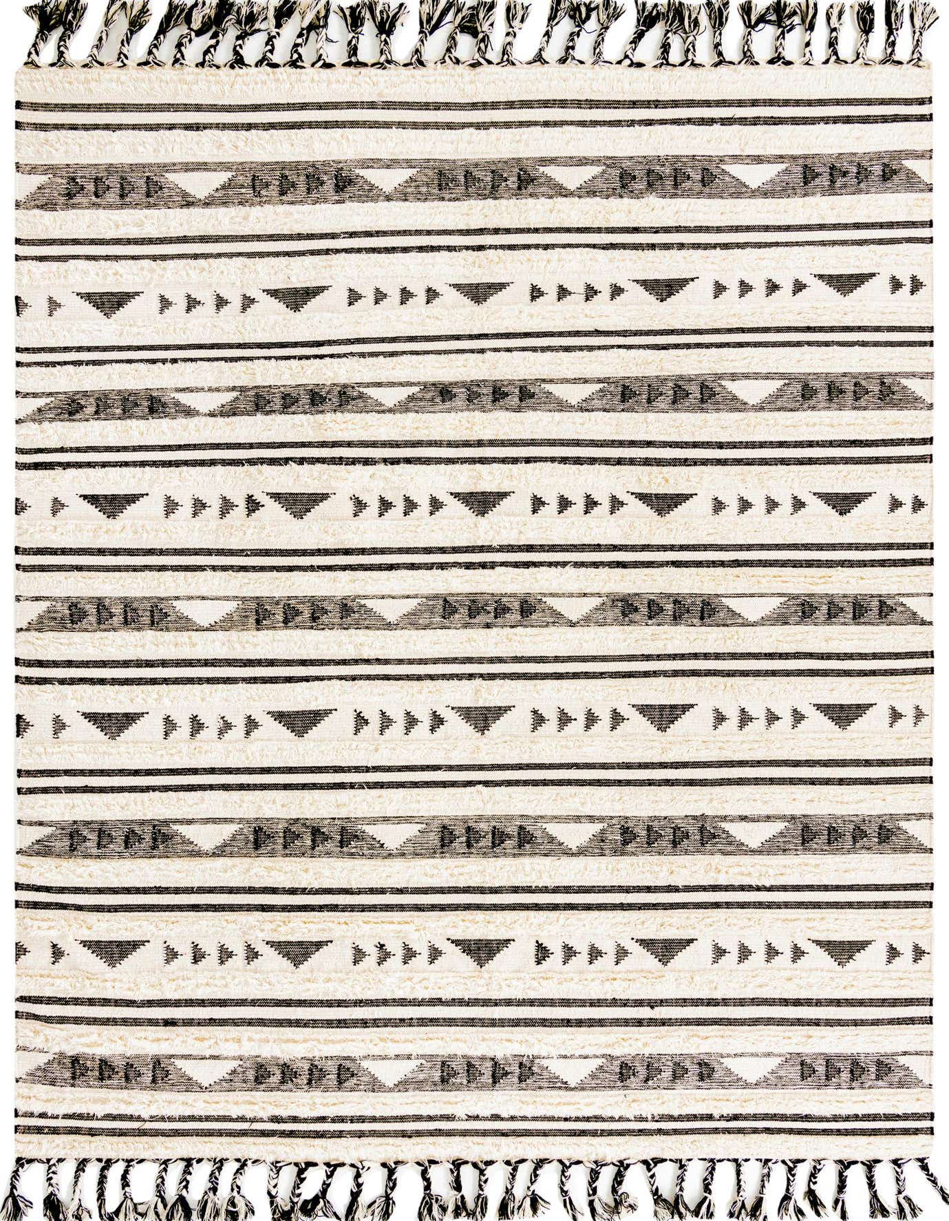 A 9x12 rectangular black and white tribal area rug with a shag pile and decorative tassels.