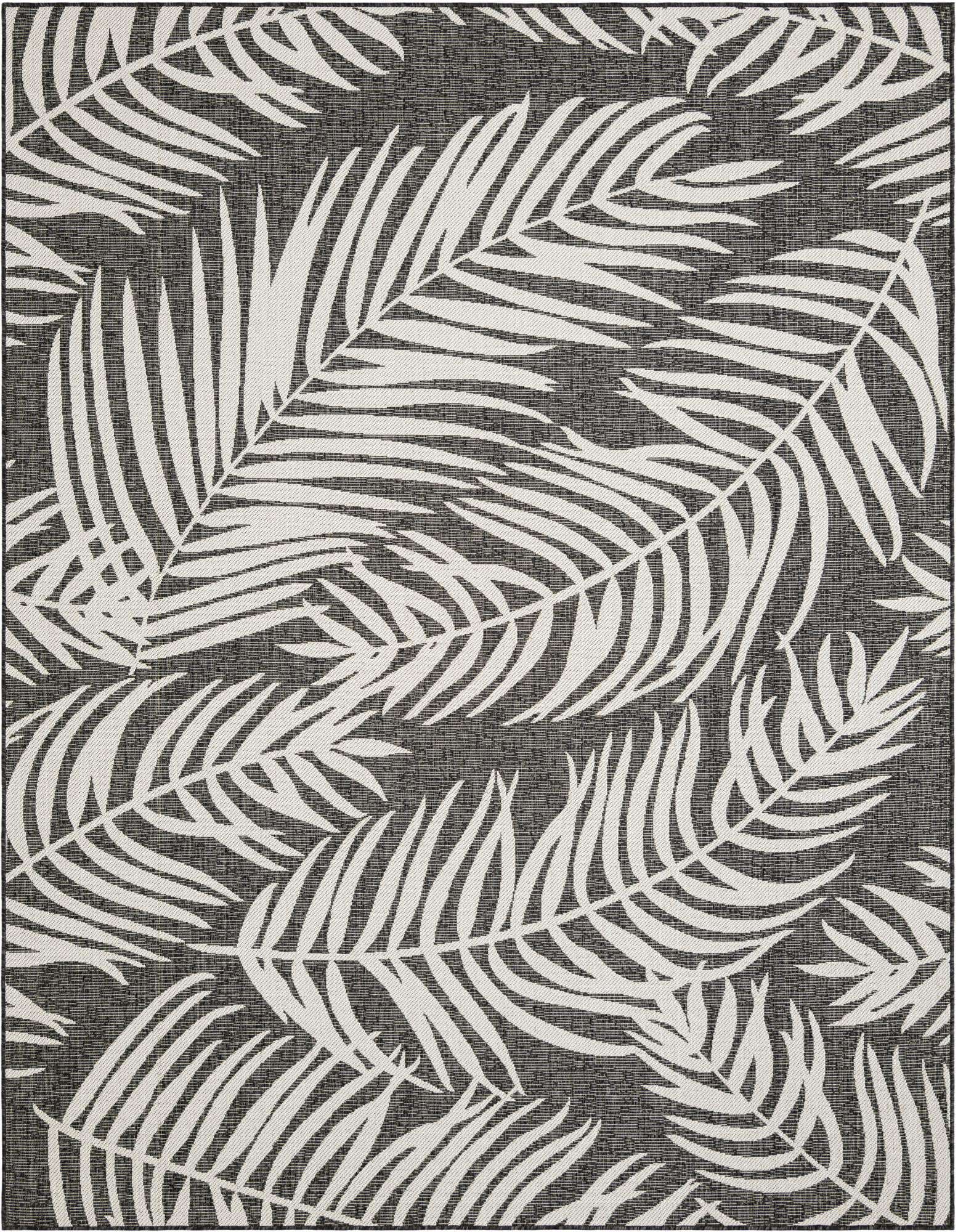 An 8x10 rectangular black and white botanical rug featuring large white palm leaves scattered across a dark gray background, suitable for indoor or outdoor use.
