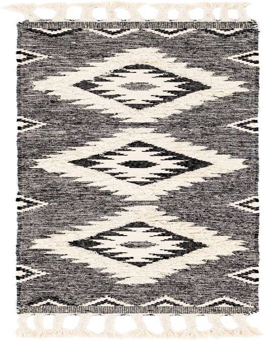A black and white tribal runner rug with large diamond patterns and braided tassels, ideal for a hallway.