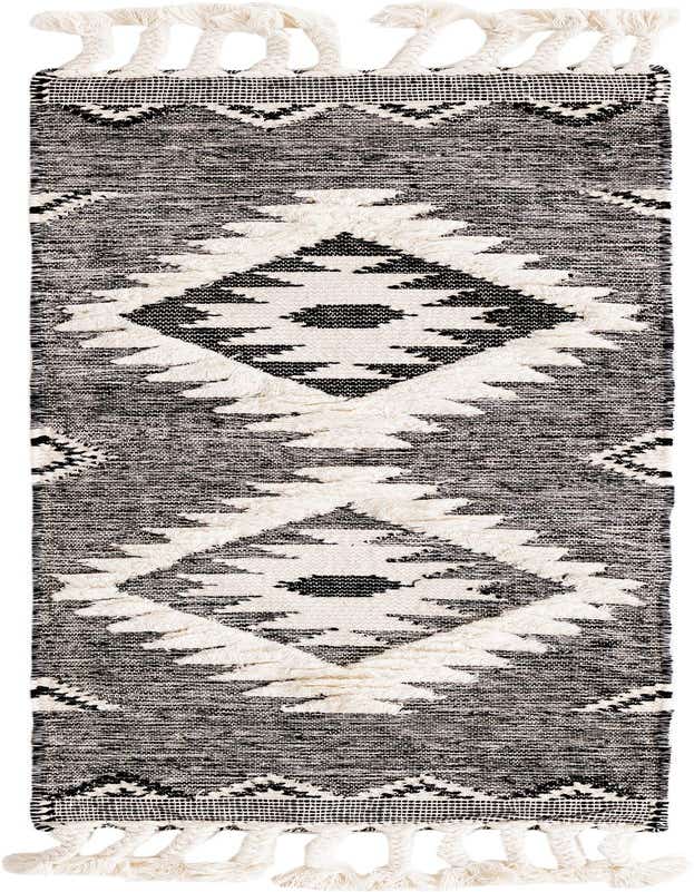 A 6 ft black and white wool runner rug with a tribal bohemian diamond pattern and braided tassels.