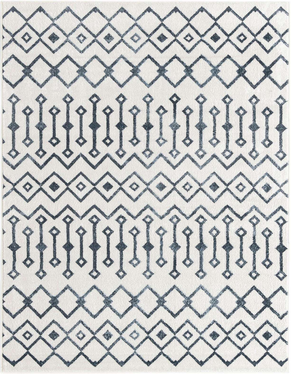A 5x8 rectangular indoor rug featuring a repeating tribal trellis pattern in varying shades of blue on an ivory background.