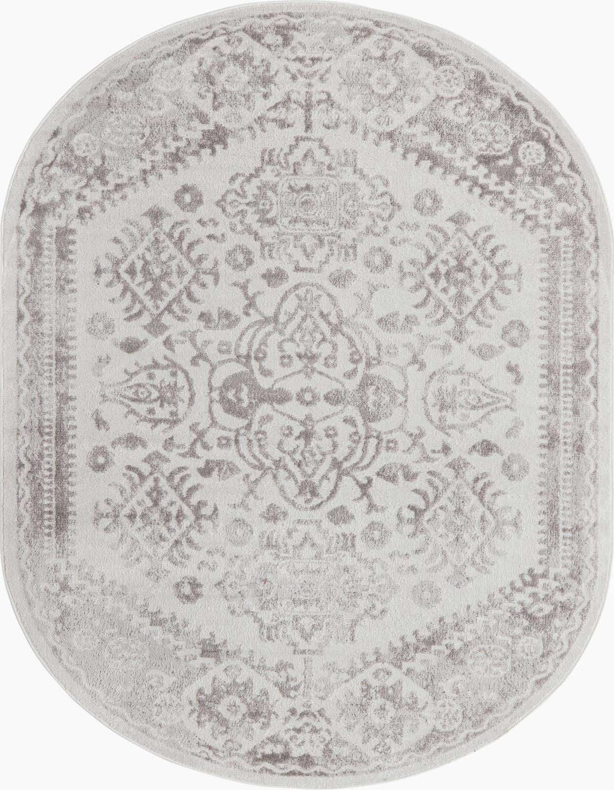 An oval 5' 3 x 8' 0 ivory and cream rug with a distressed Bohemian medallion pattern.