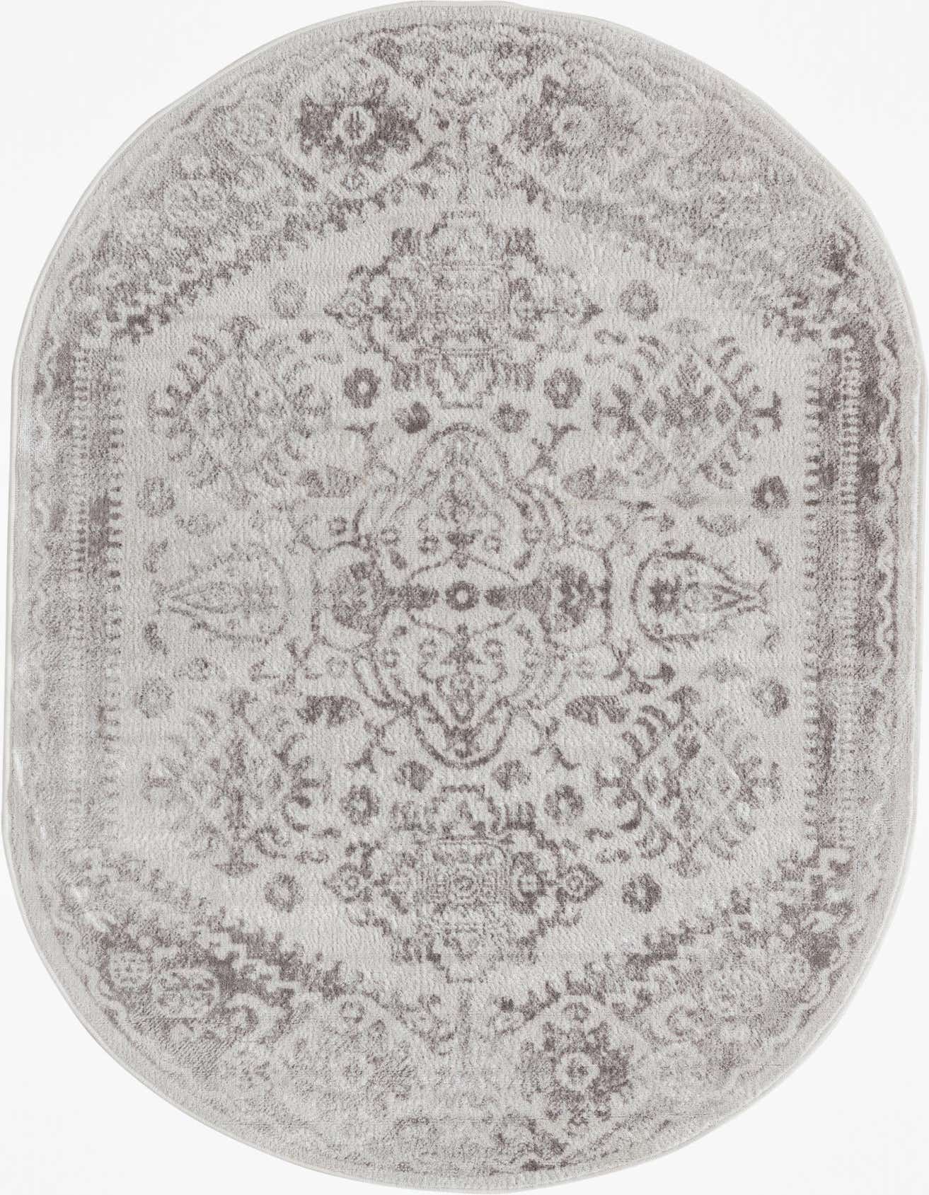 An oval 4'x6' ivory and cream rug with a distressed medallion and floral bohemian pattern.