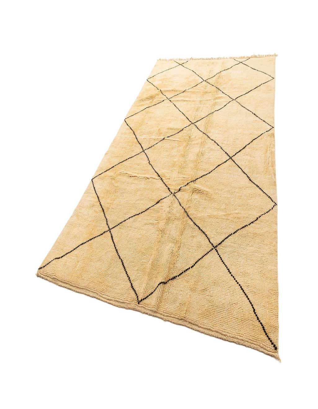 A 6x9 rectangular ivory wool rug with a black diamond pattern, shown at an angle on a white background.