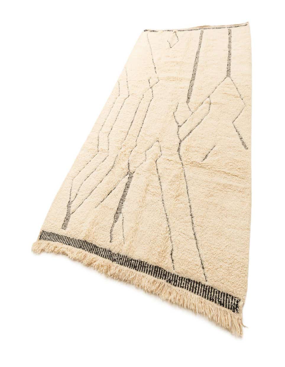 A 6x9 rectangular ivory wool rug with a medium pile and abstract black lines, featuring fringed ends.