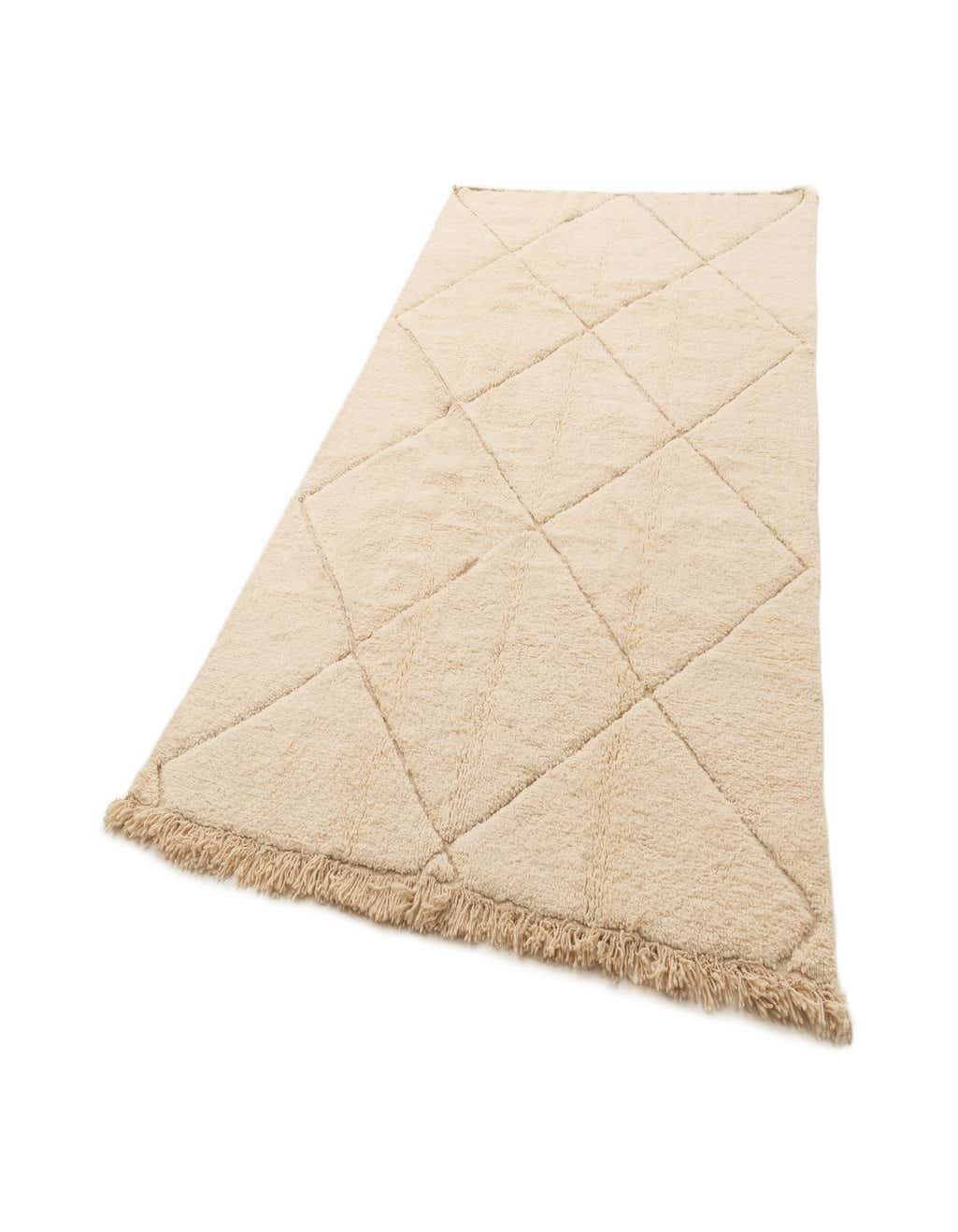 A rectangular 6x9 ivory wool area rug with a subtle diamond pattern and fringed edges, ideal for a living room.