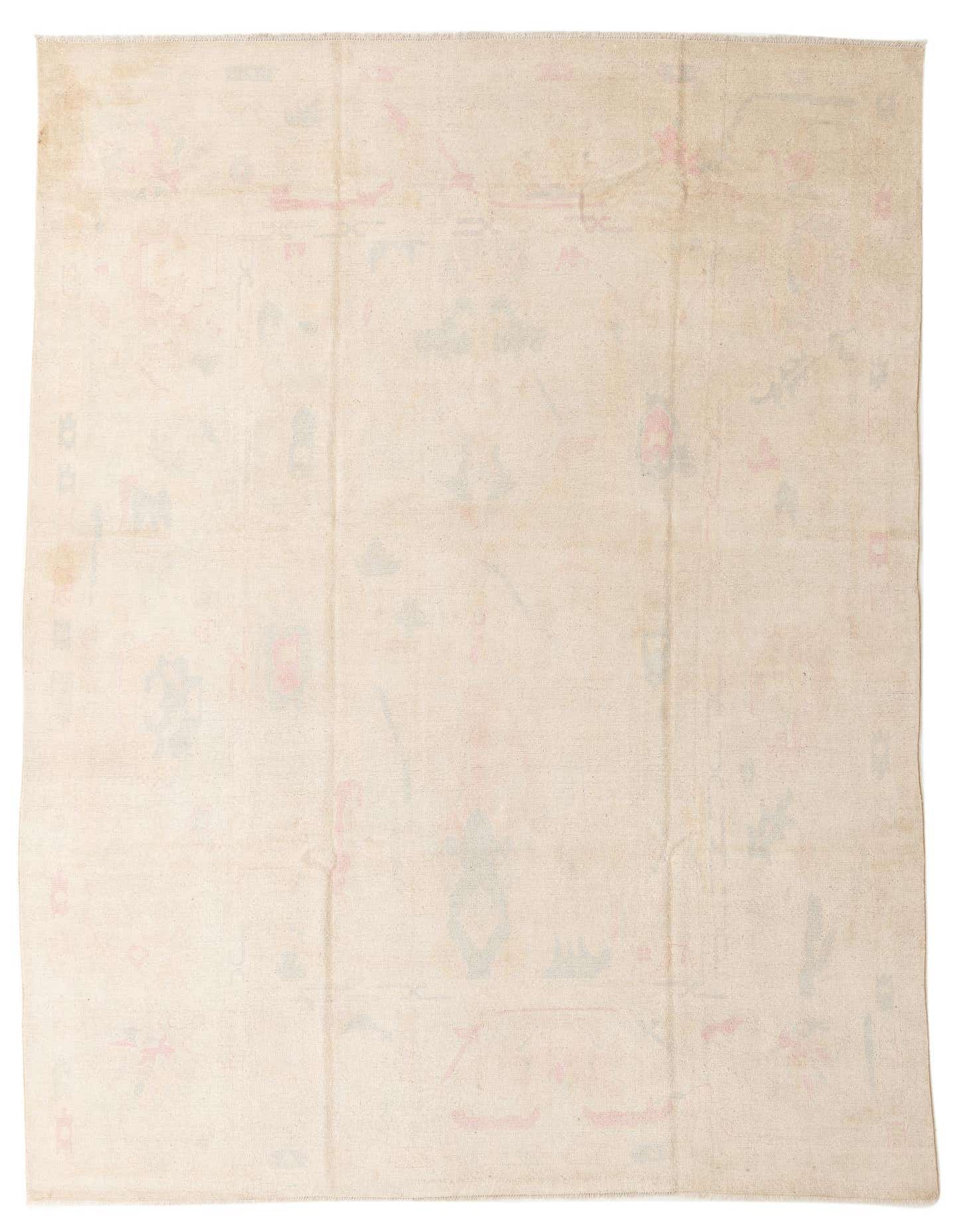 A 10x13 rectangular ivory modern wool rug with subtle, faded abstract patterns in light pink and blue.