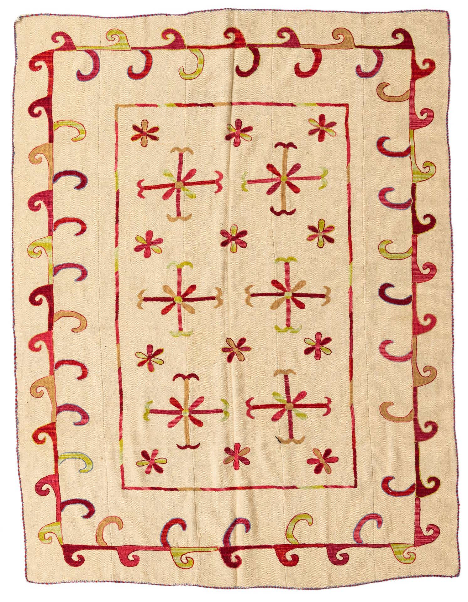 A 5x8 rectangular ivory flatweave rug with a tribal Suzani pattern in red, green, and brown, featuring a border of swirling hooks and a central field of floral motifs.