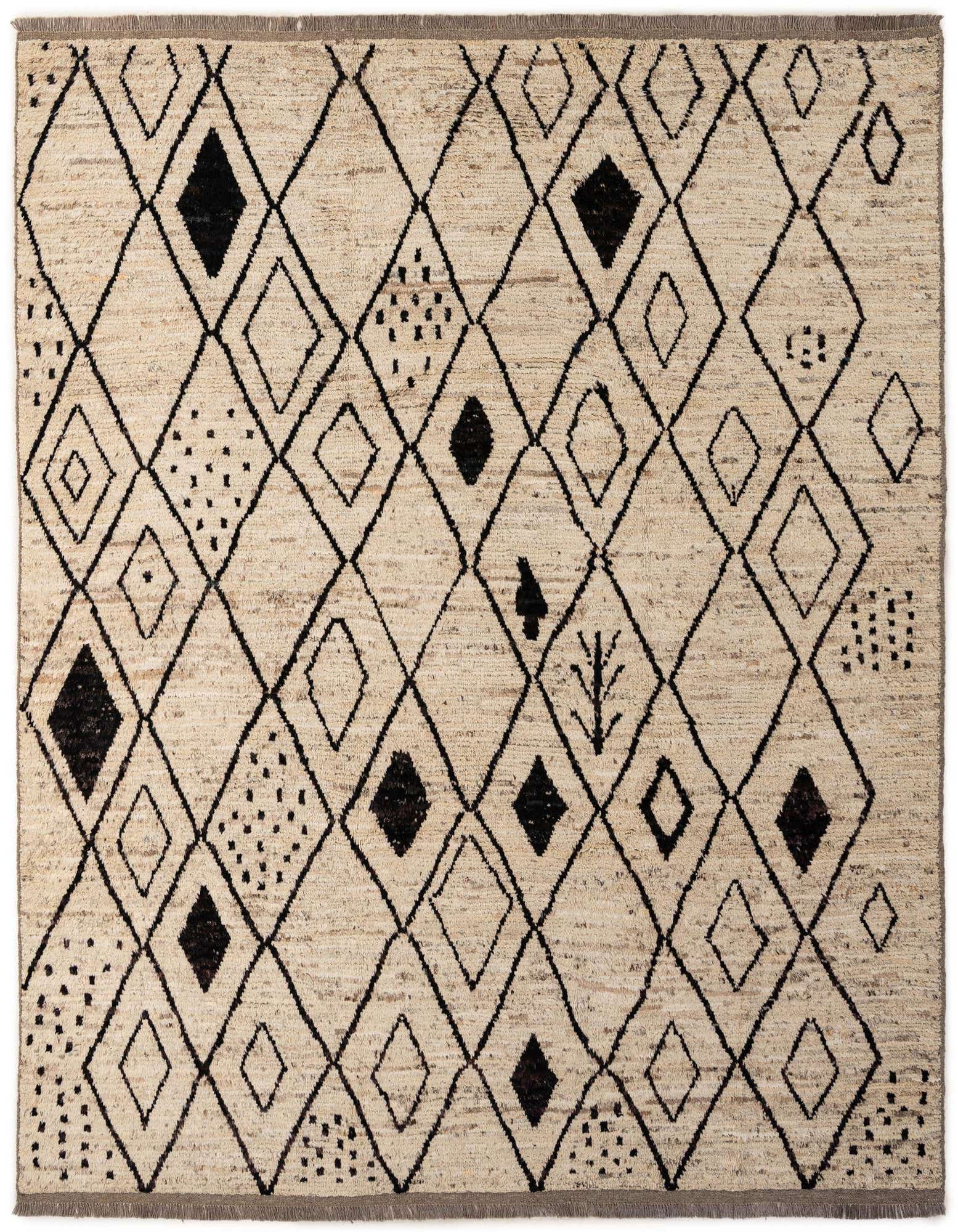 An 8x10 rectangular ivory wool rug with a tribal pattern of black outlined and solid diamonds, dots, and abstract shapes.