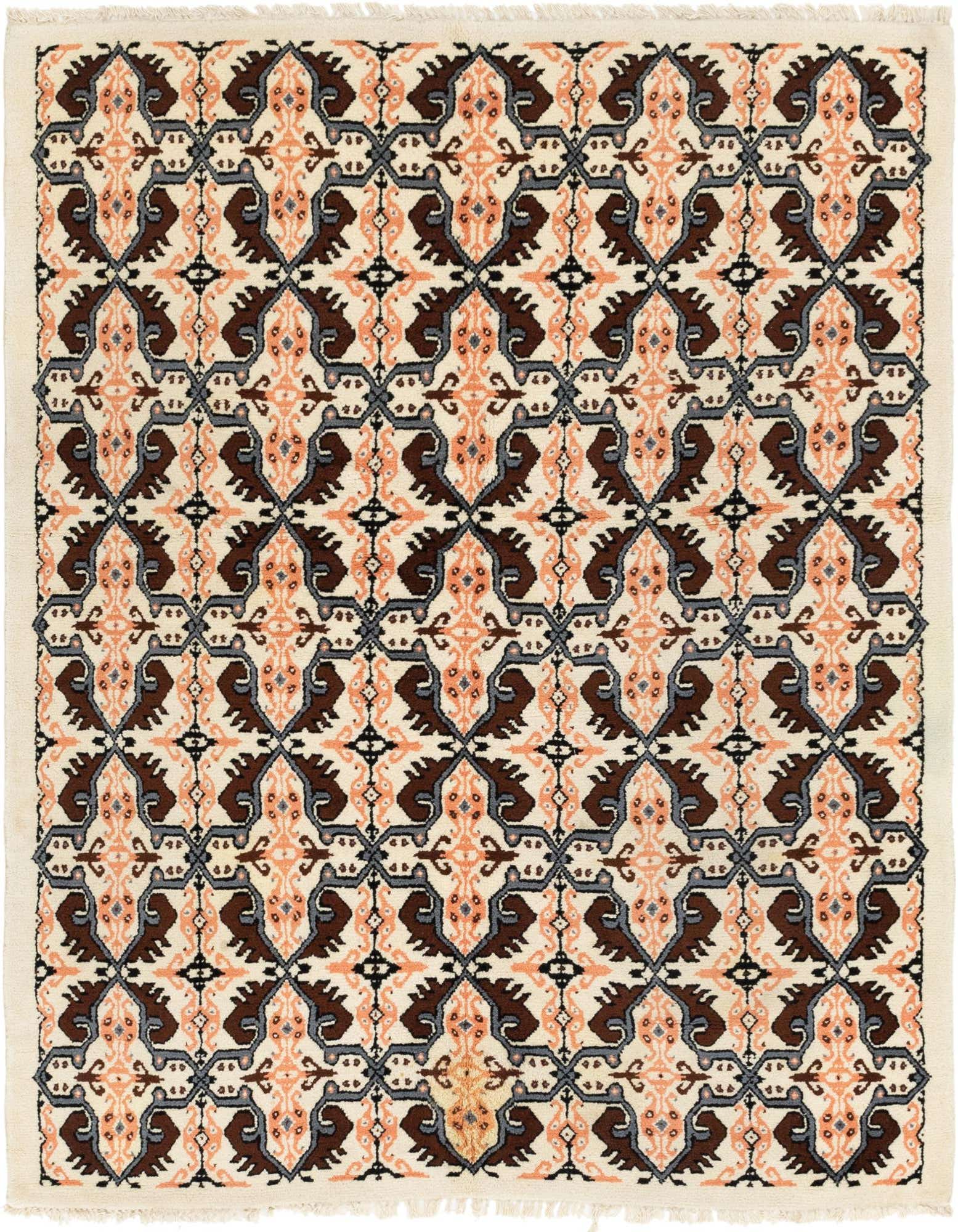 A 5x8 rectangular ivory shag rug with a repeating tribal pattern in brown, peach, and gray.