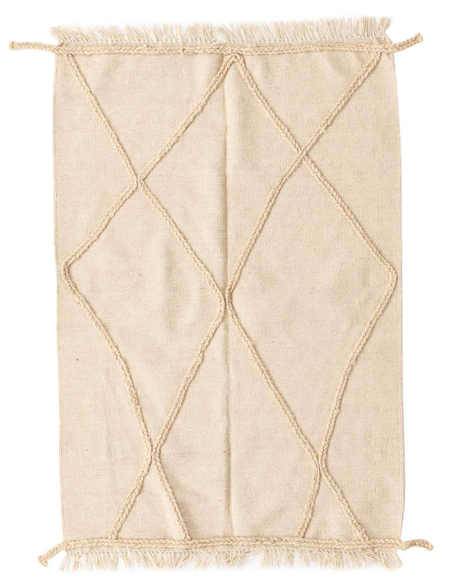 A 3x5 rectangular ivory wool shag rug with a braided diamond tribal pattern and fringed edges.
